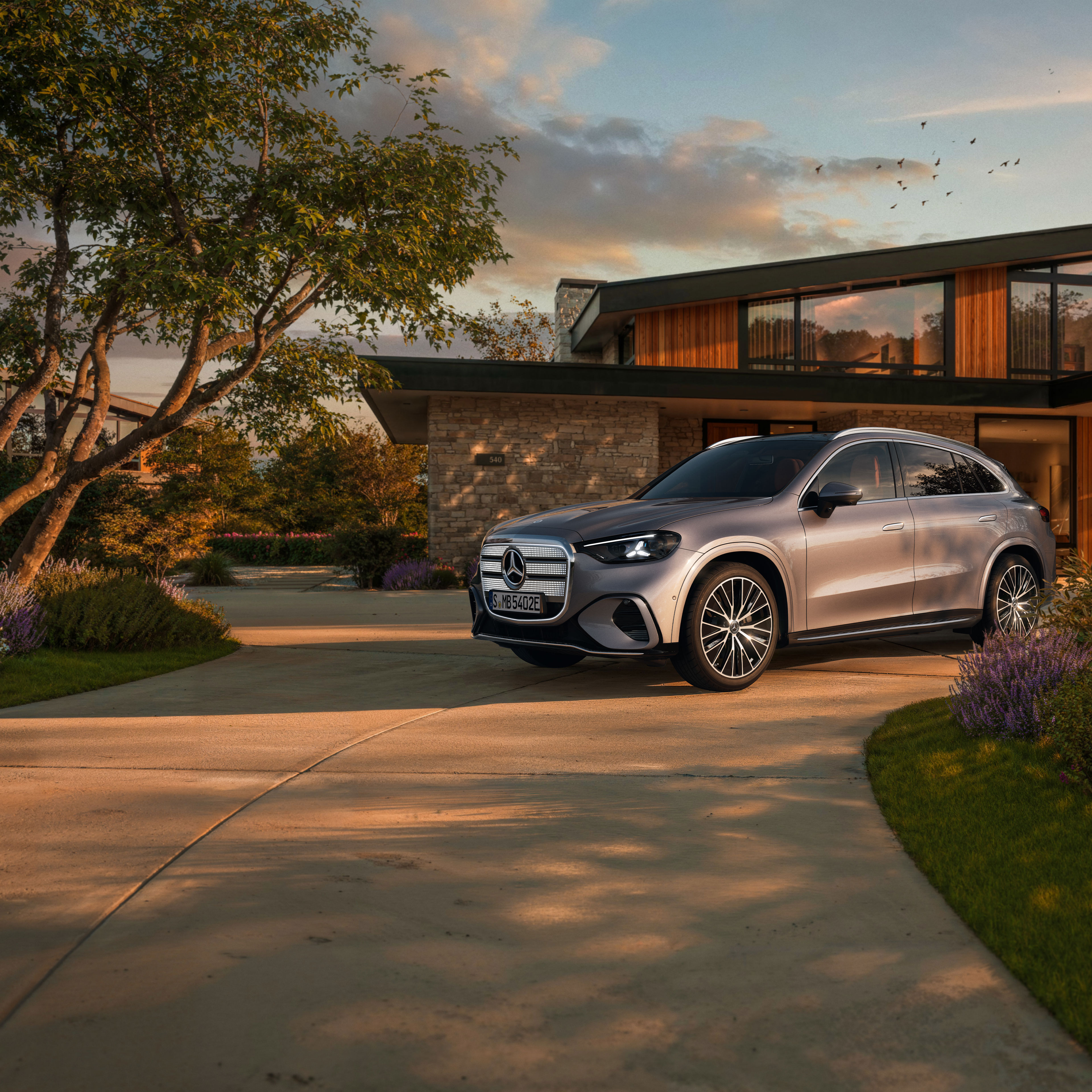 Visual de un GLC plateado de Mercedes-Benz aparcado al frente de una casa