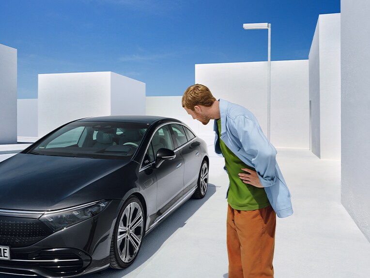 Un hombre delante de un Mercedes-Benz.