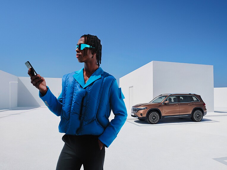 Un hombre está conectado con su smartphone al Mercedes-Benz.