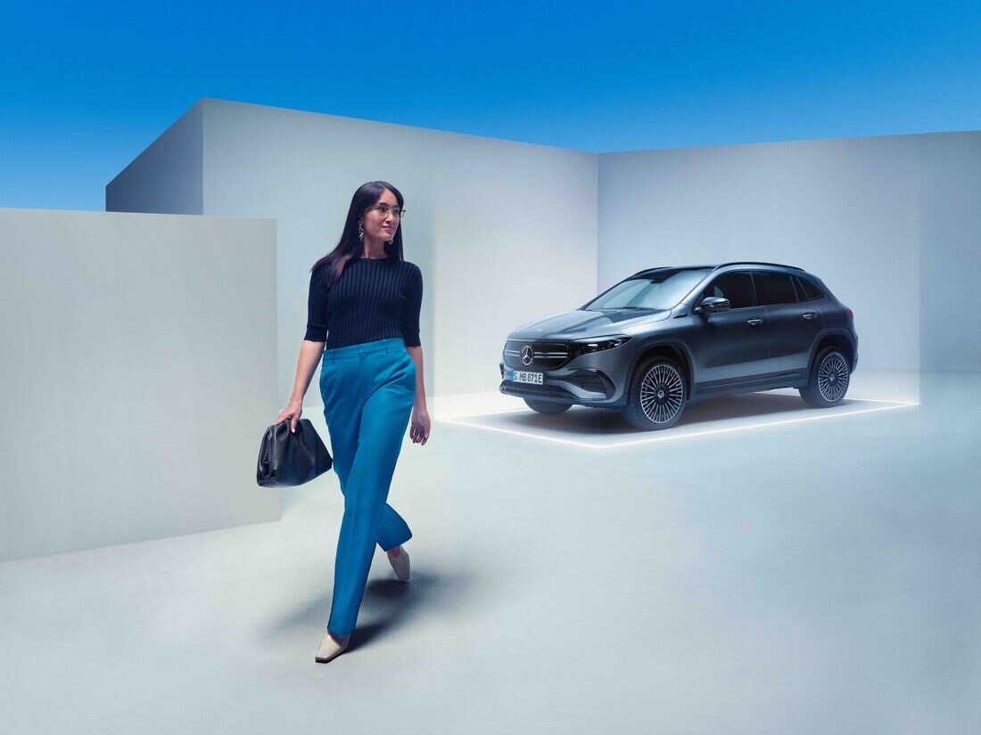 Una mujer se aleja caminando de su Mercedes-Benz aparcado.