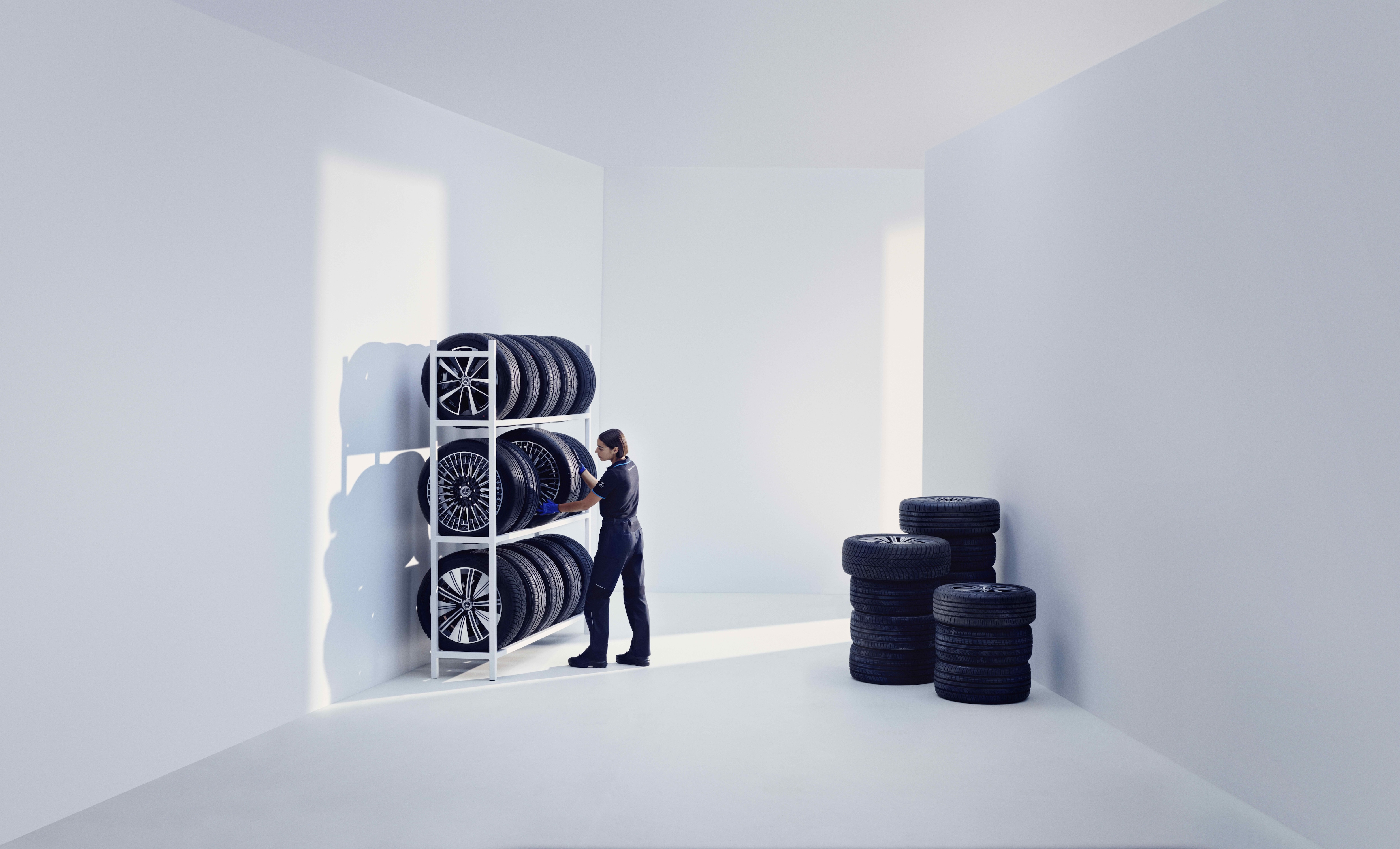 MO | Mercedes-Benz visual de un hombre colocando unos neumáticos en una sala blanca