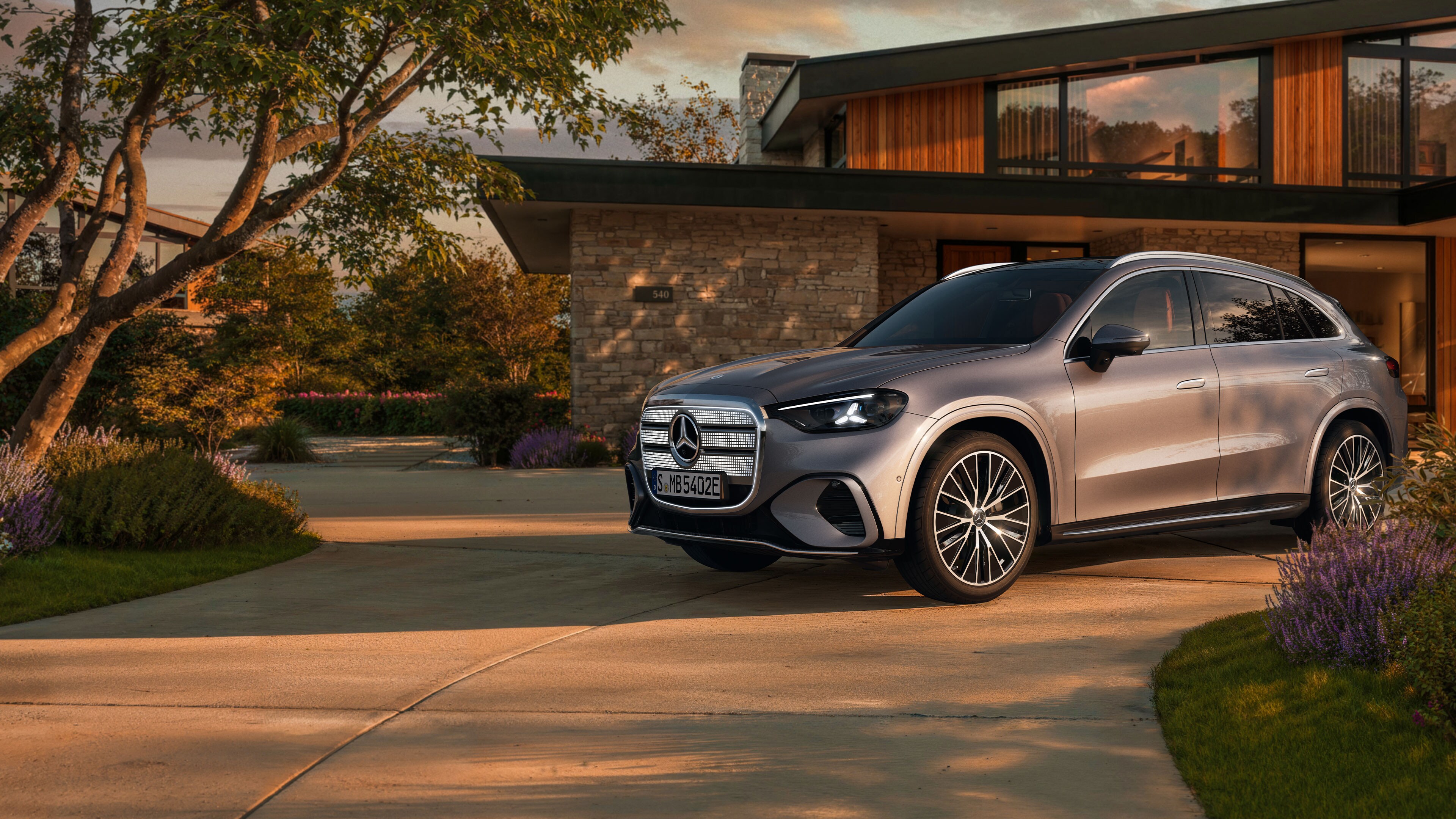 Visual de un GLC plateado de Mercedes-Benz aparcado al frente de una casa