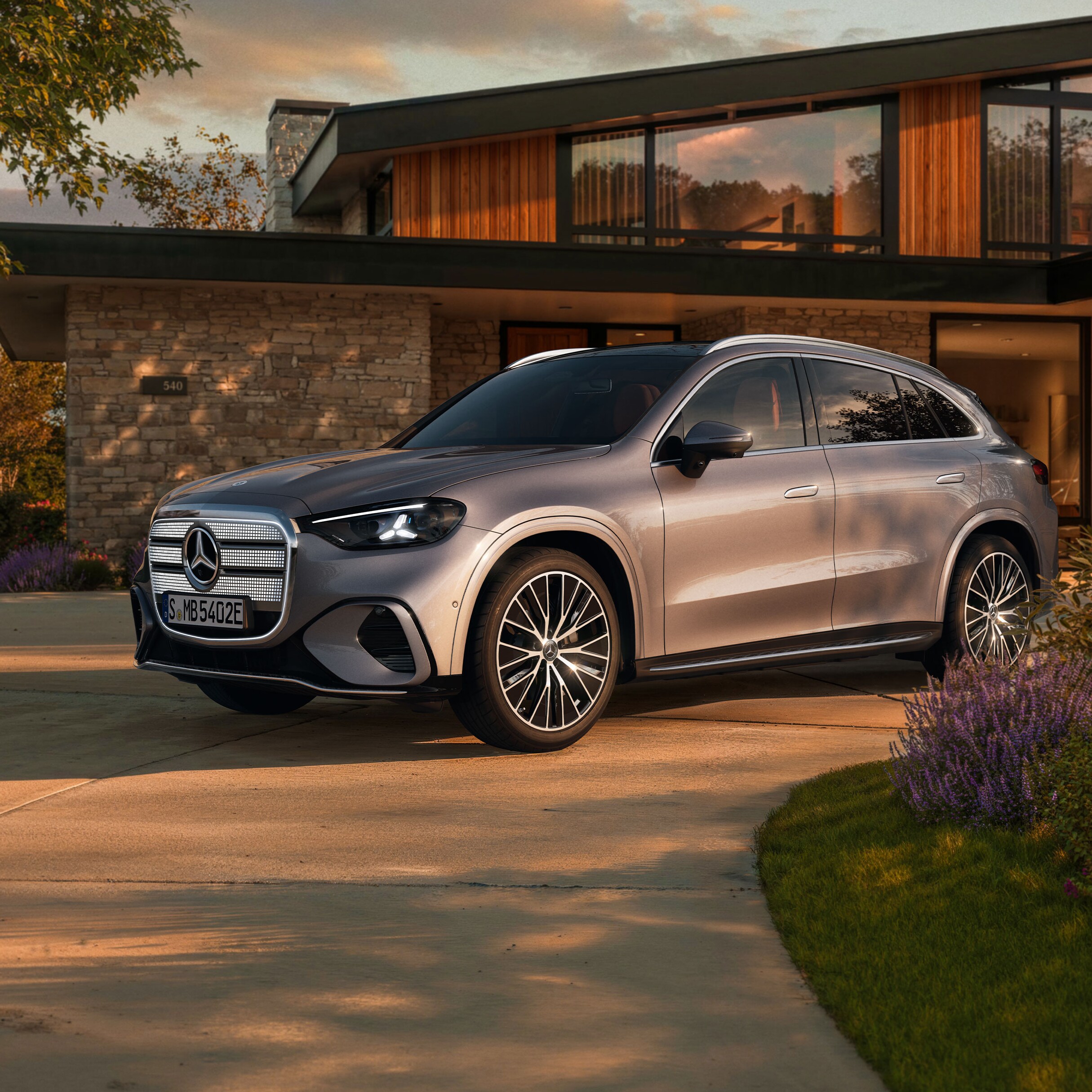 Visual de un GLC plateado de Mercedes-Benz aparcado al frente de una casa