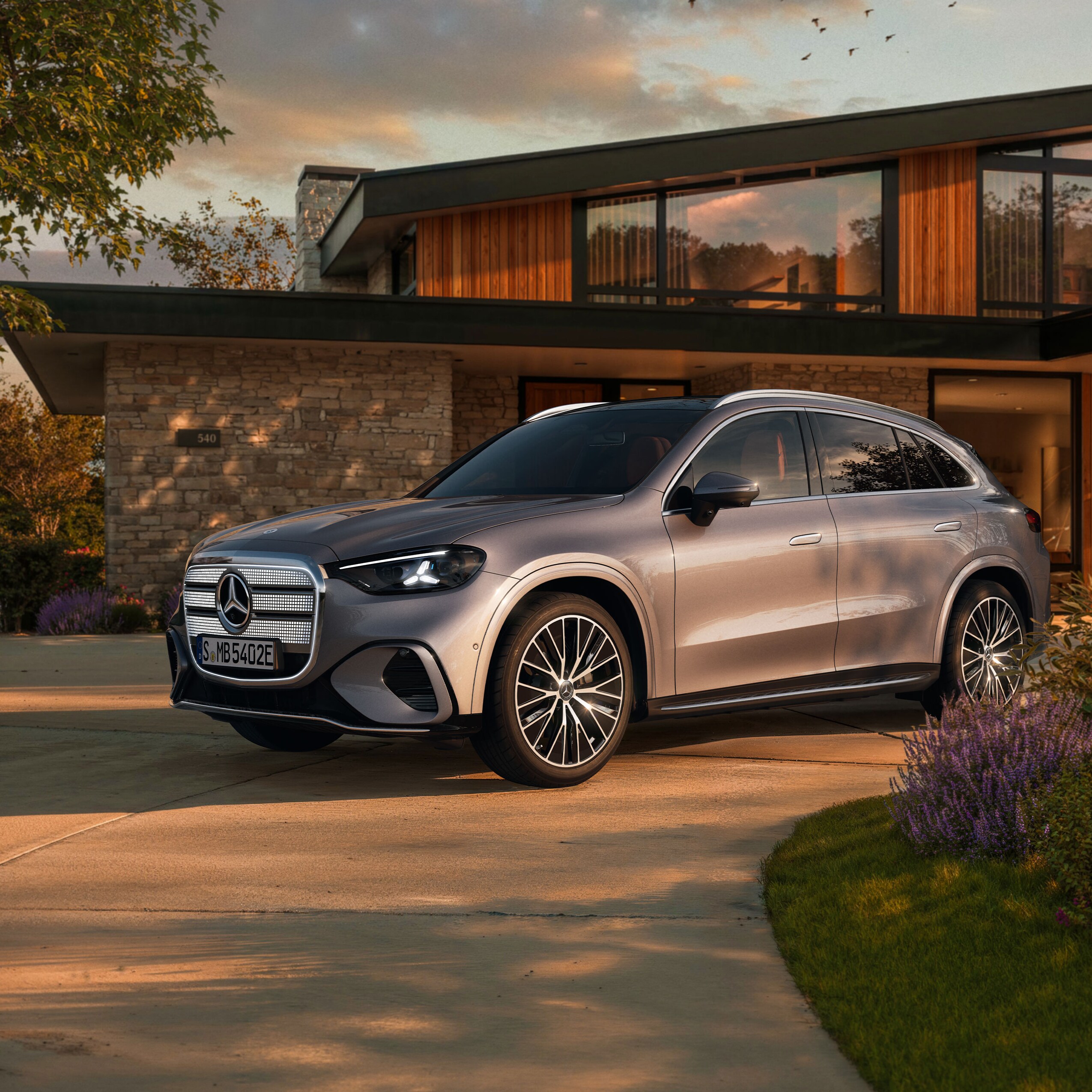 Visual lateral de un GLC eléctrico gris aparcado fuera de una casa