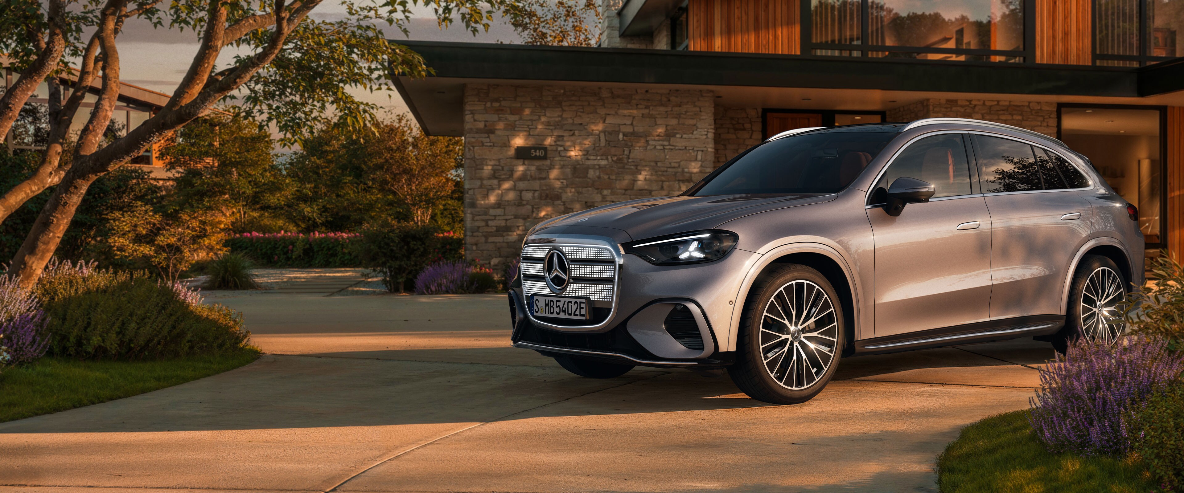 El GLC eléctrico gris de Mercedes-Benz aparcado fuera de una casa
