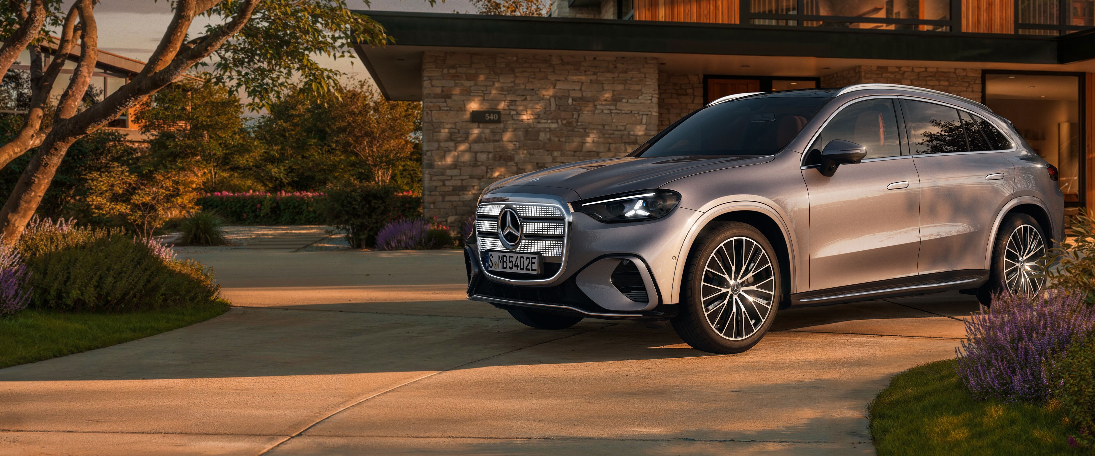 El nuevo GLC eléctrico en gris aparcado fuera de una casa