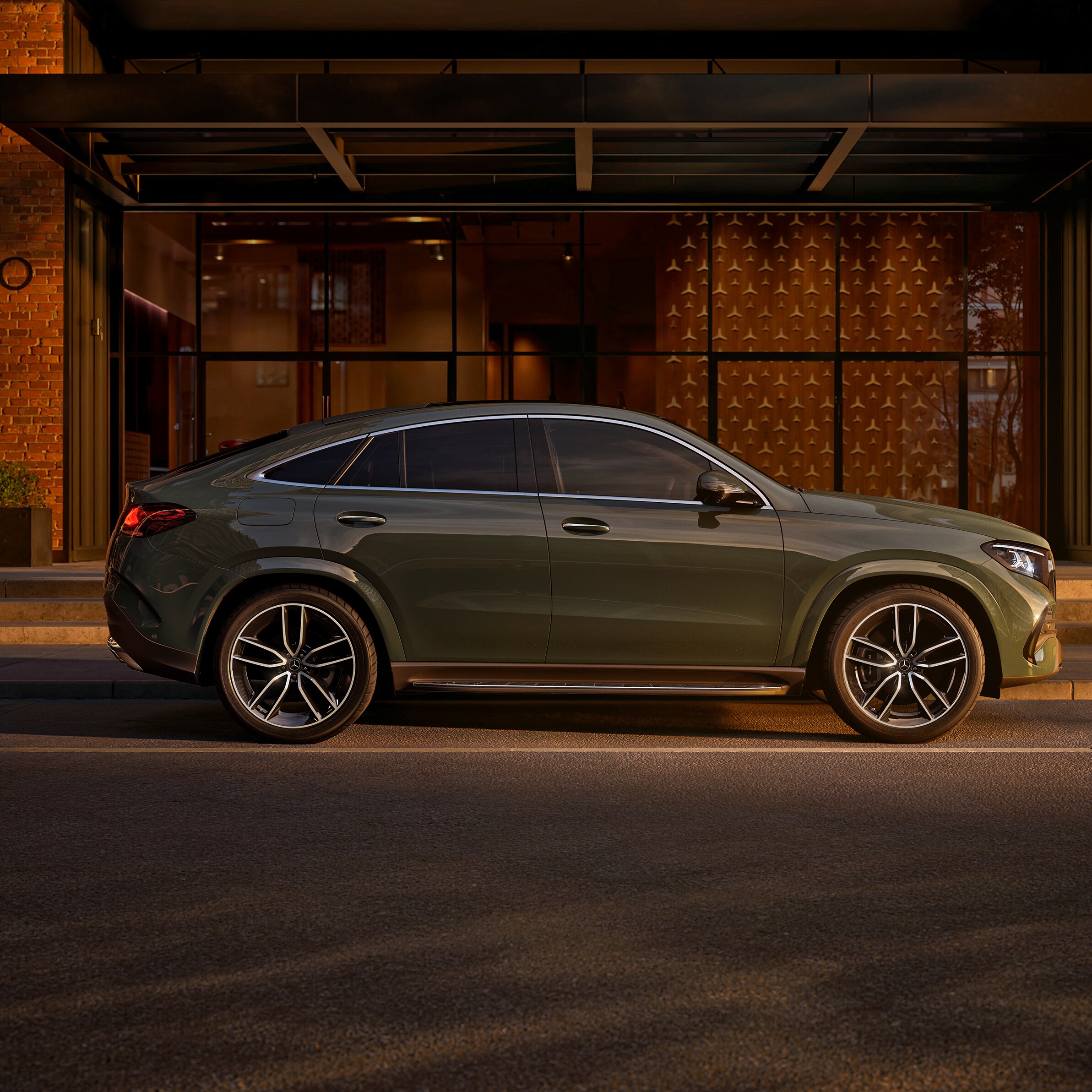 Vista lateral de un GLE Coupé verde aparcado fuera de un edificio