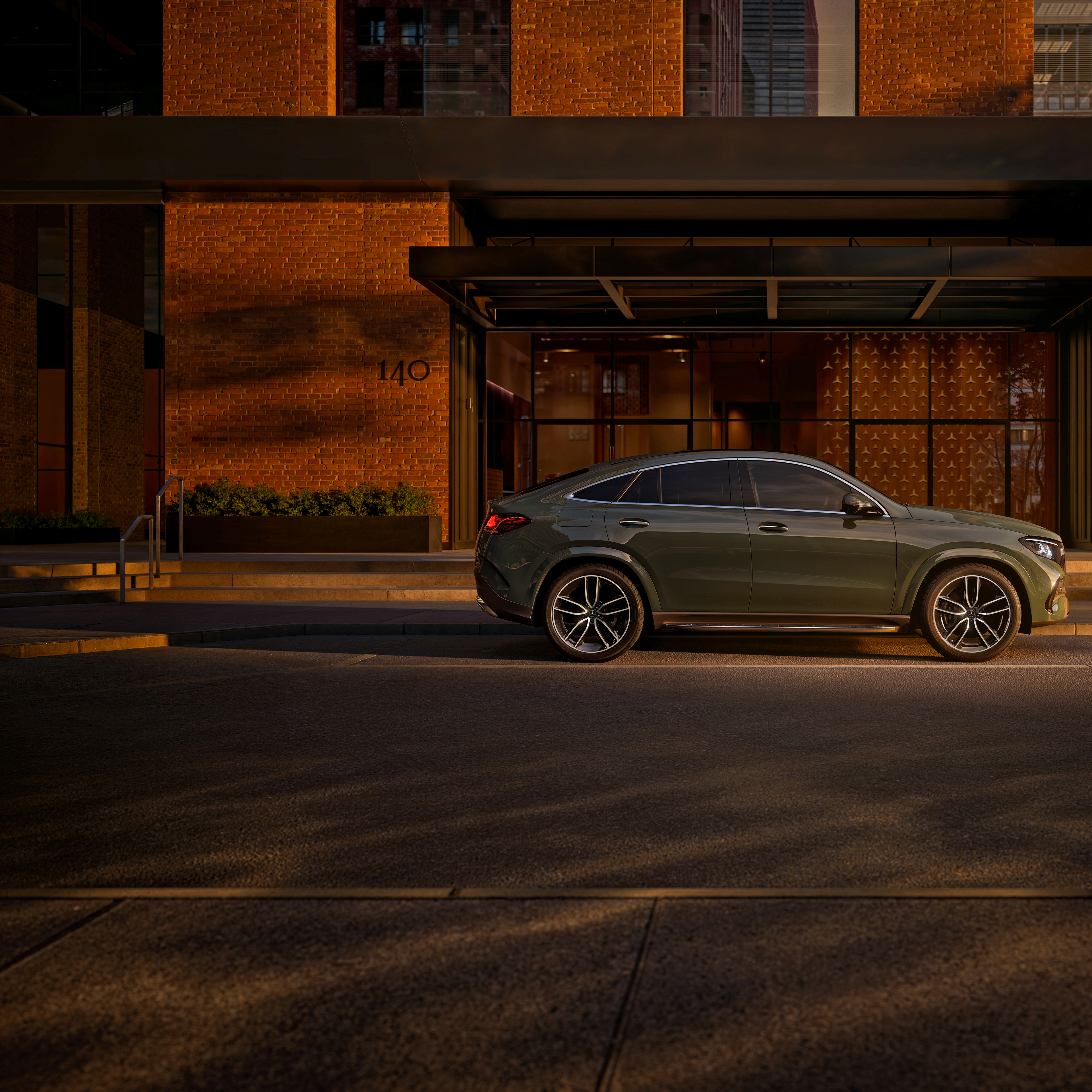 GLE Coupé | Mercedes-Benz Vista lateral de un GLE Coupé verde aparcado fuera de un edificio