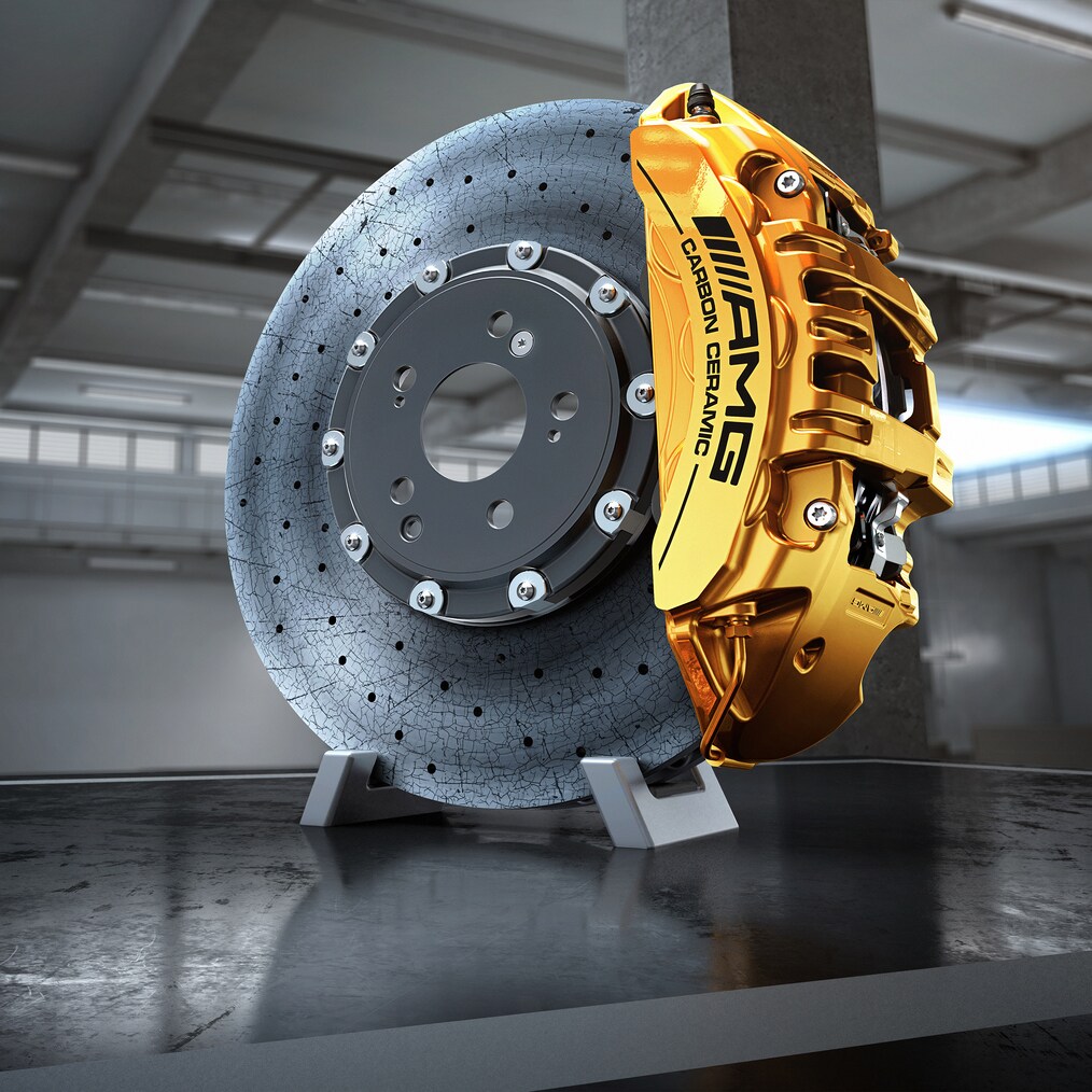 Primer plano de un disco de freno AMG cerámico de material compuesto de alto rendimiento con una pinza de freno pintada en amarillo.