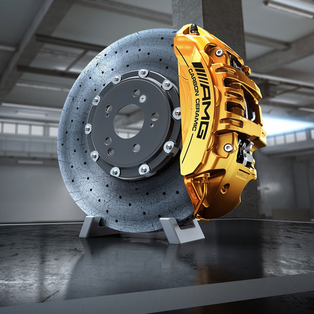 Primer plano de una llanta de aleación AMG a través de la que se ve el sistema de frenos cerámicos de alto rendimiento AMG con discos compuestos.