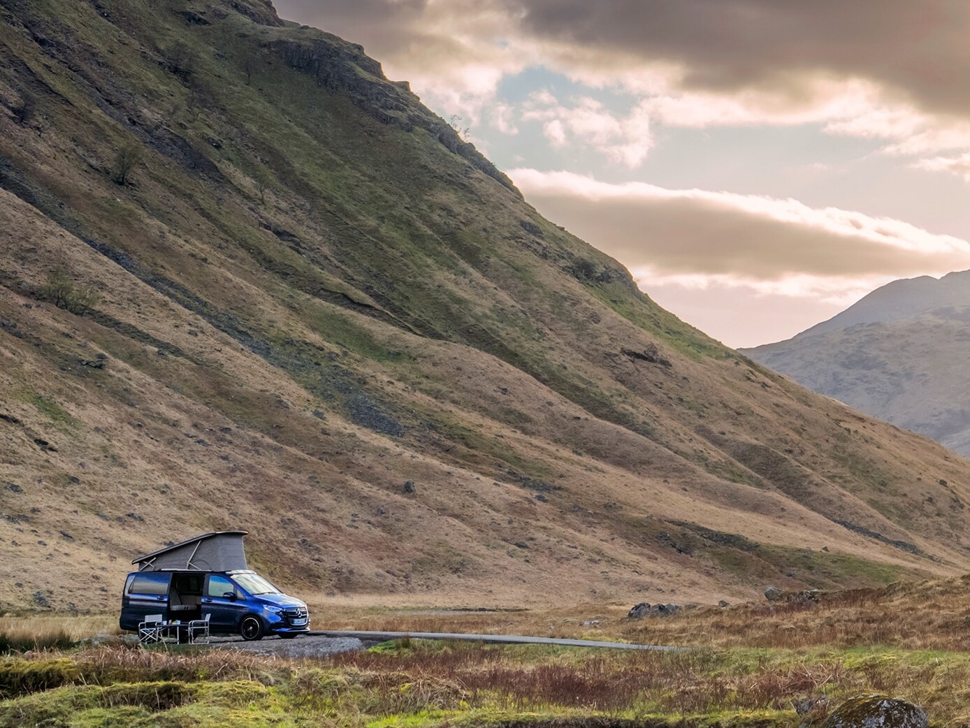 La autocaravana Mercedes‑Benz Marco Polo en un espectacular paisaje montañoso, poniendo de relieve la libertad de la vida en el furgón, la aventura al aire libre y el confort de viaje de alta gama.
