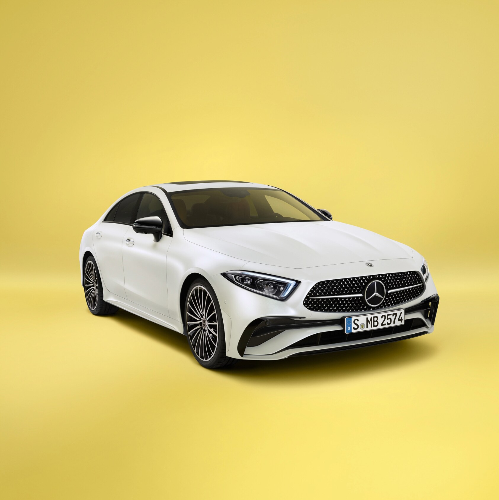 Un CLS Coupé blanco de Mercedes-Benz sobre un fondo amarillo