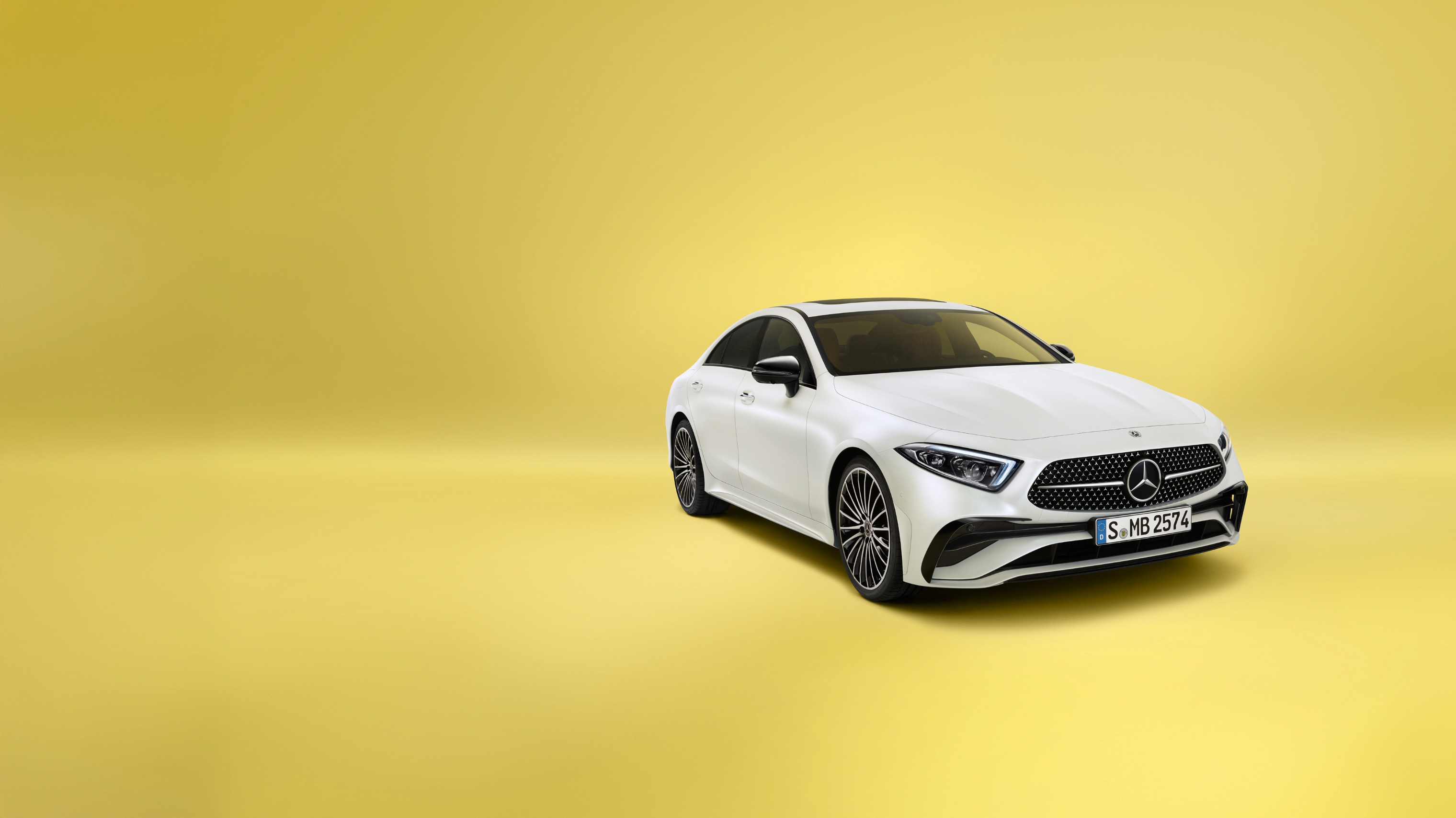 Vista general | CLS | Mercedes-Benz Un CLS Coupé blanco de Mercedes-Benz sobre un fondo amarillo