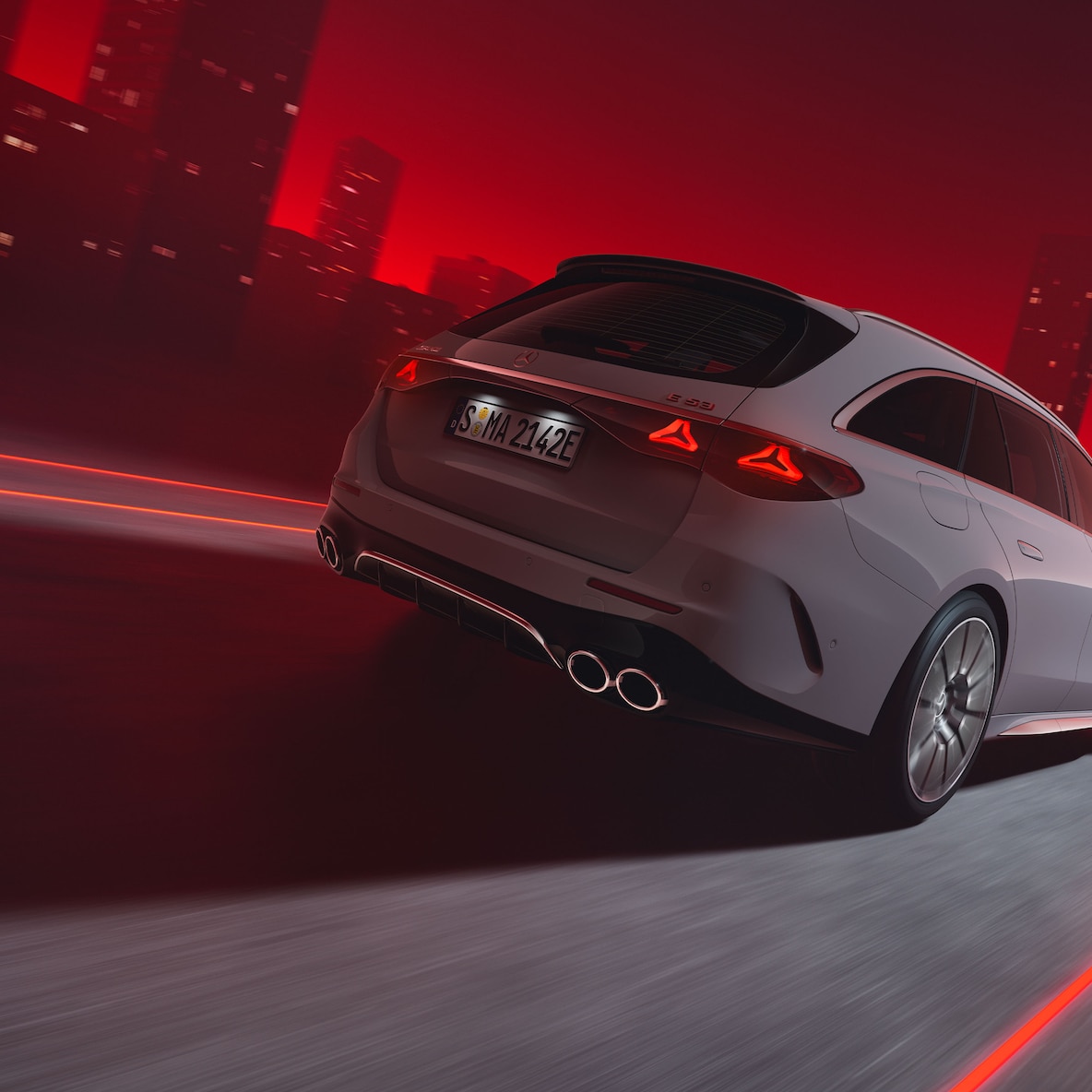 Vista trasera de un Mercedes-AMG E 53 HYBRID 4MATIC+ Estate en marcha sobre un fondo rojo.