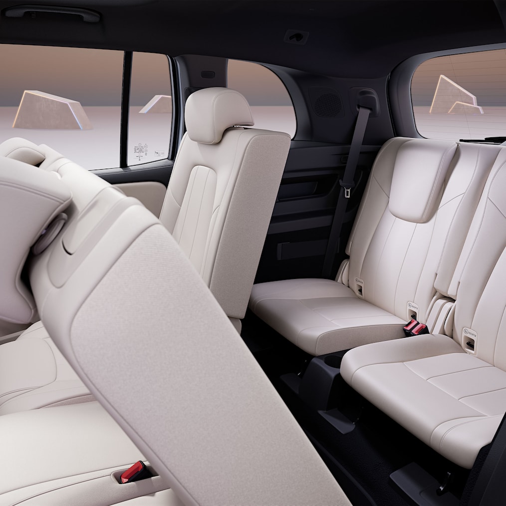 Vista a través de puerta lateral trasera abierta mostrando segunda y tercera fila de asientos.