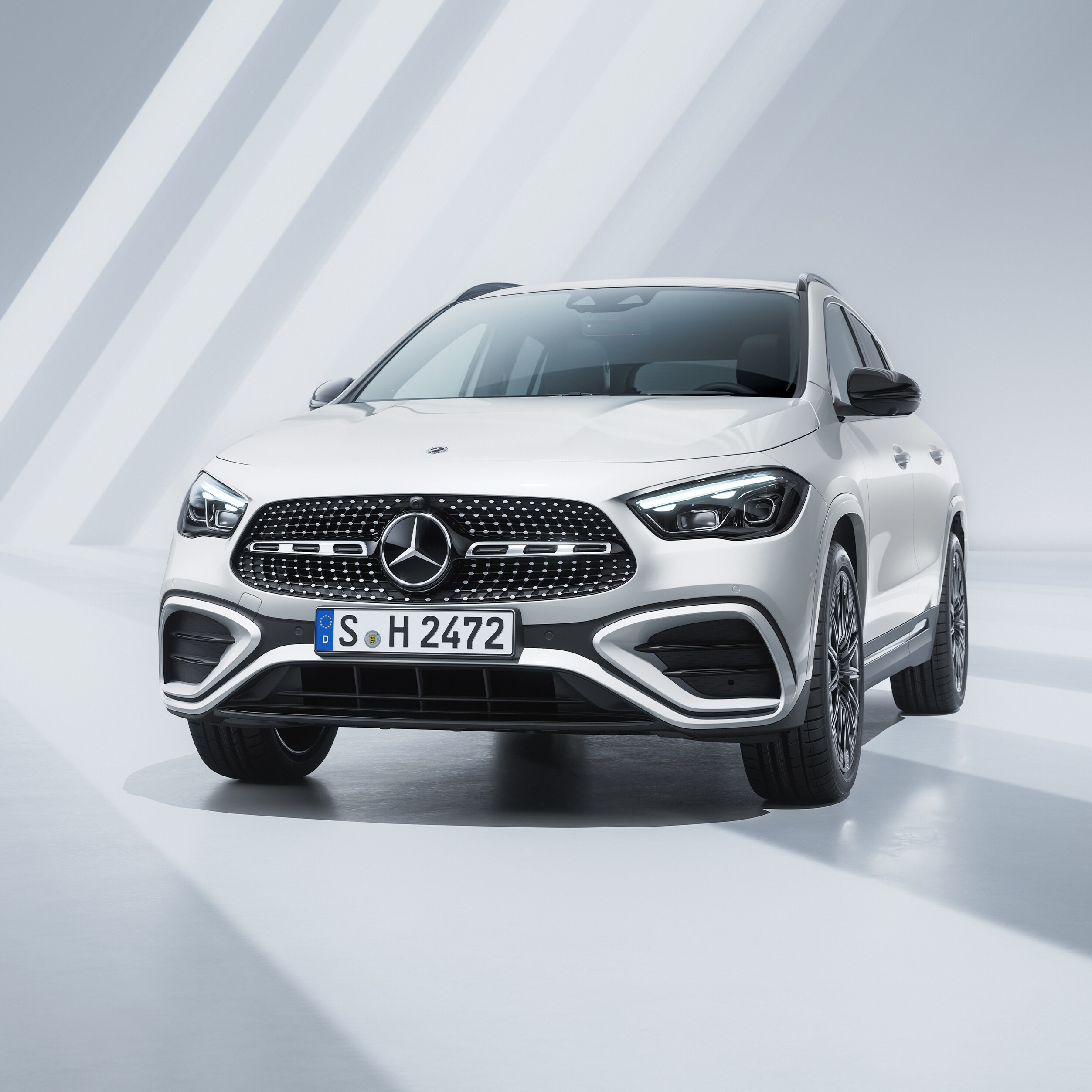 Visual de un GLA blanco de Mercedes-Benz en un fondo gris con franjas blancas