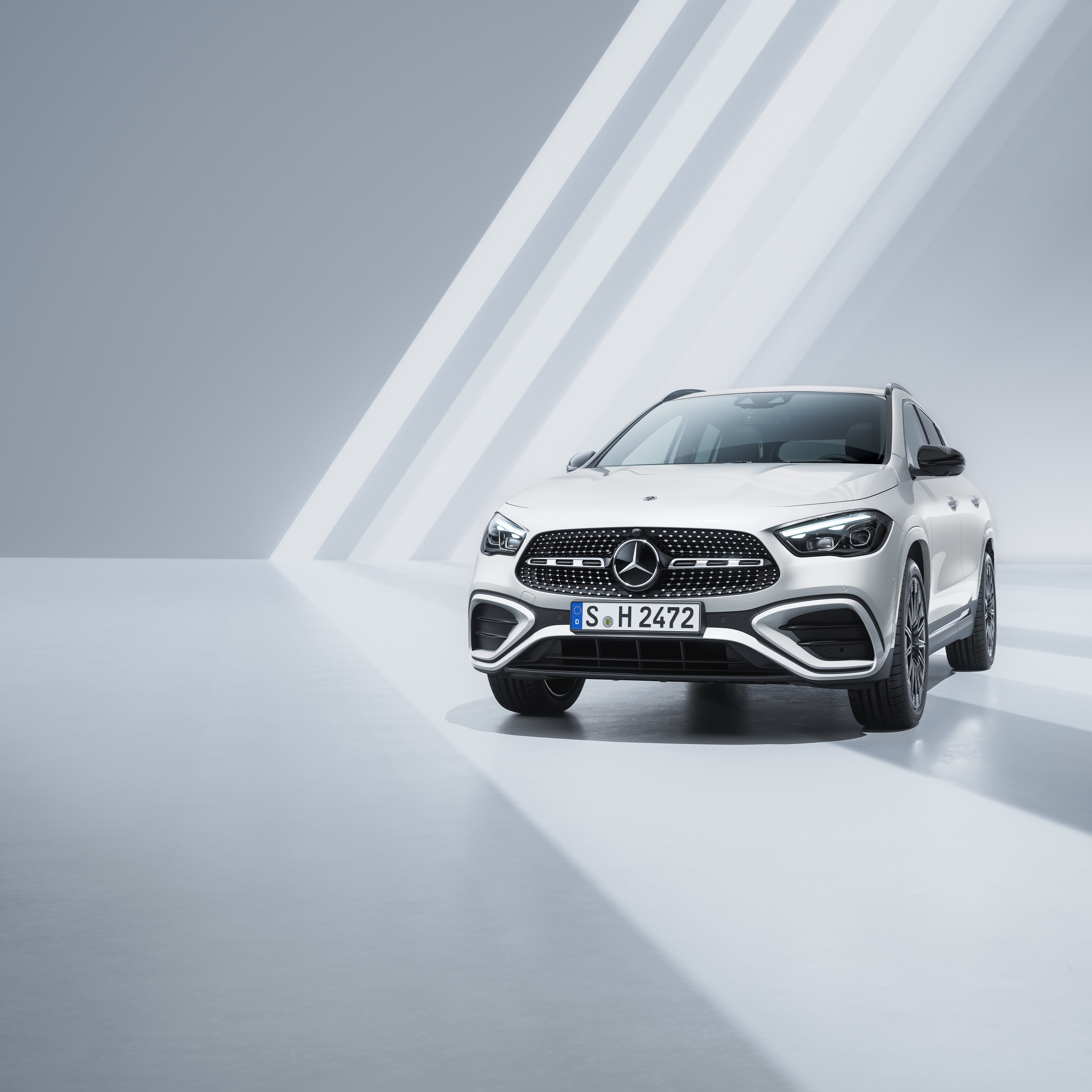 GLA | Mercedes-Benz Visual de un GLA blanco de Mercedes-Benz en un fondo gris con franjas blancas