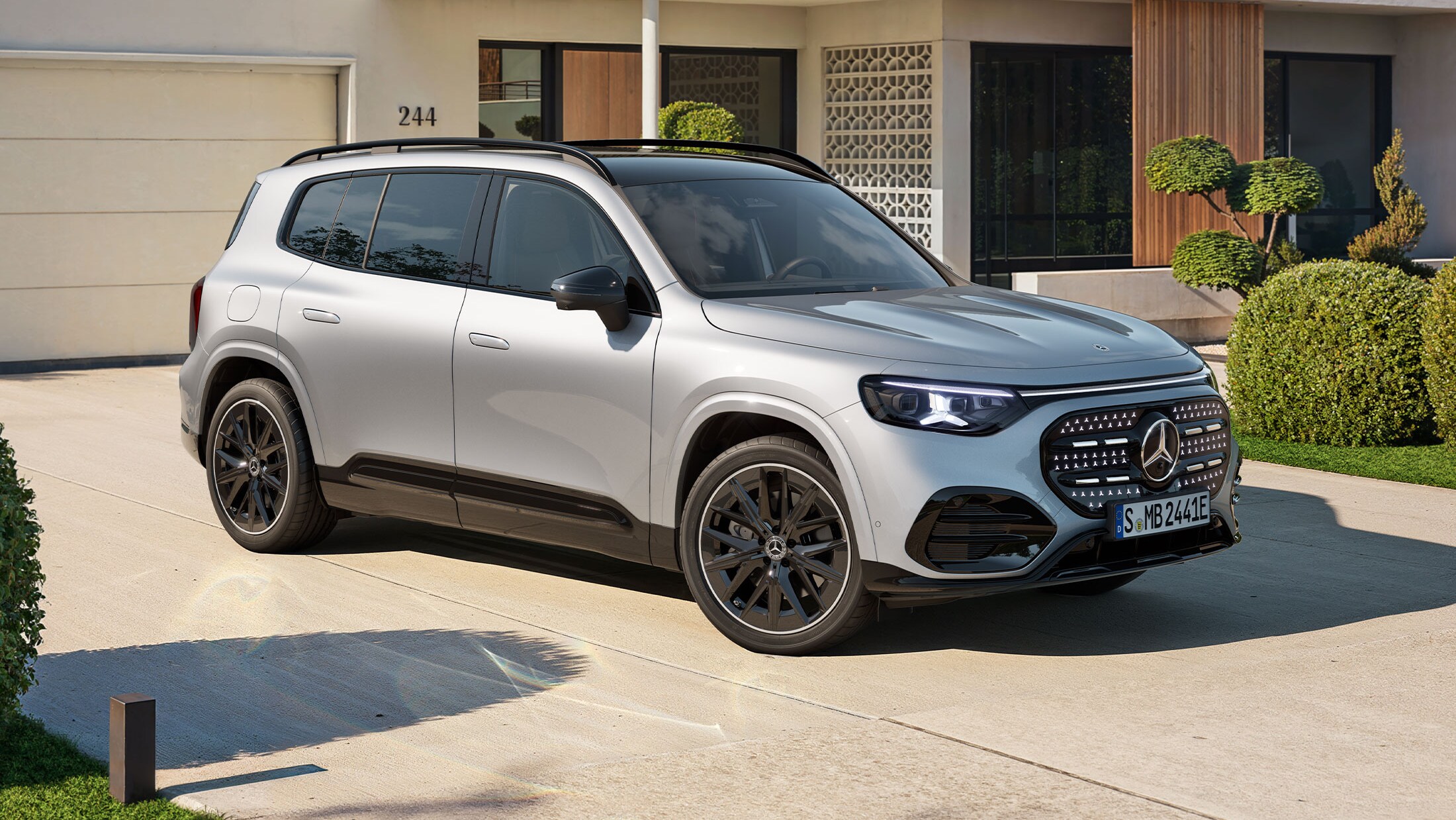 Visual de un GLB plateado de Mercedes-Benz aparcado al frente de una casa