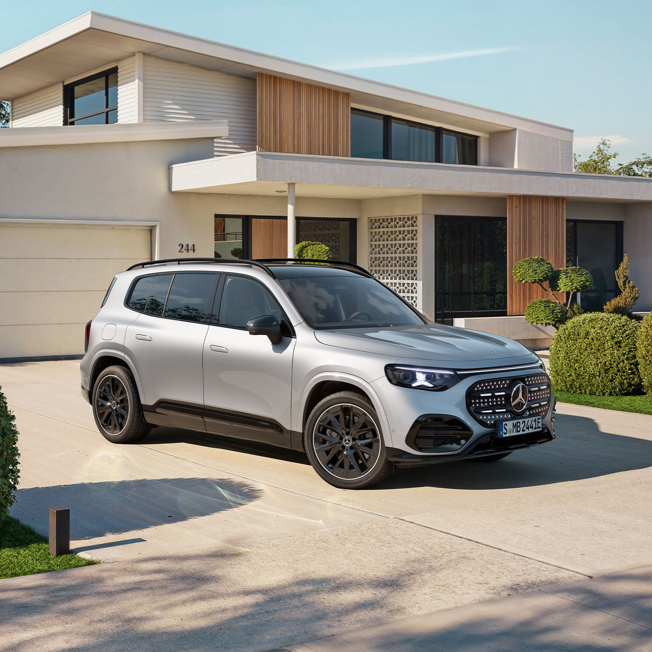 Visual de un GLB plateado de Mercedes-Benz aparcado al frente de una casa