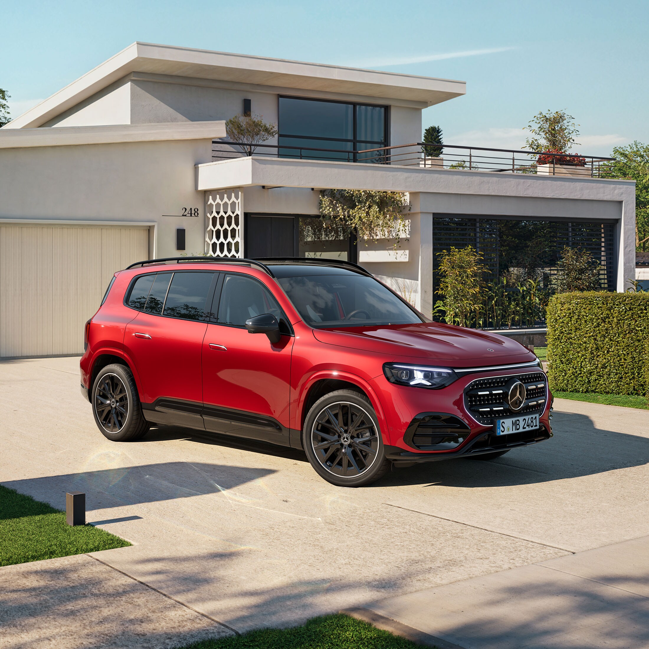 Imagen de un GLB rojo de Mercedes-Benz aparcado al frente de una casa