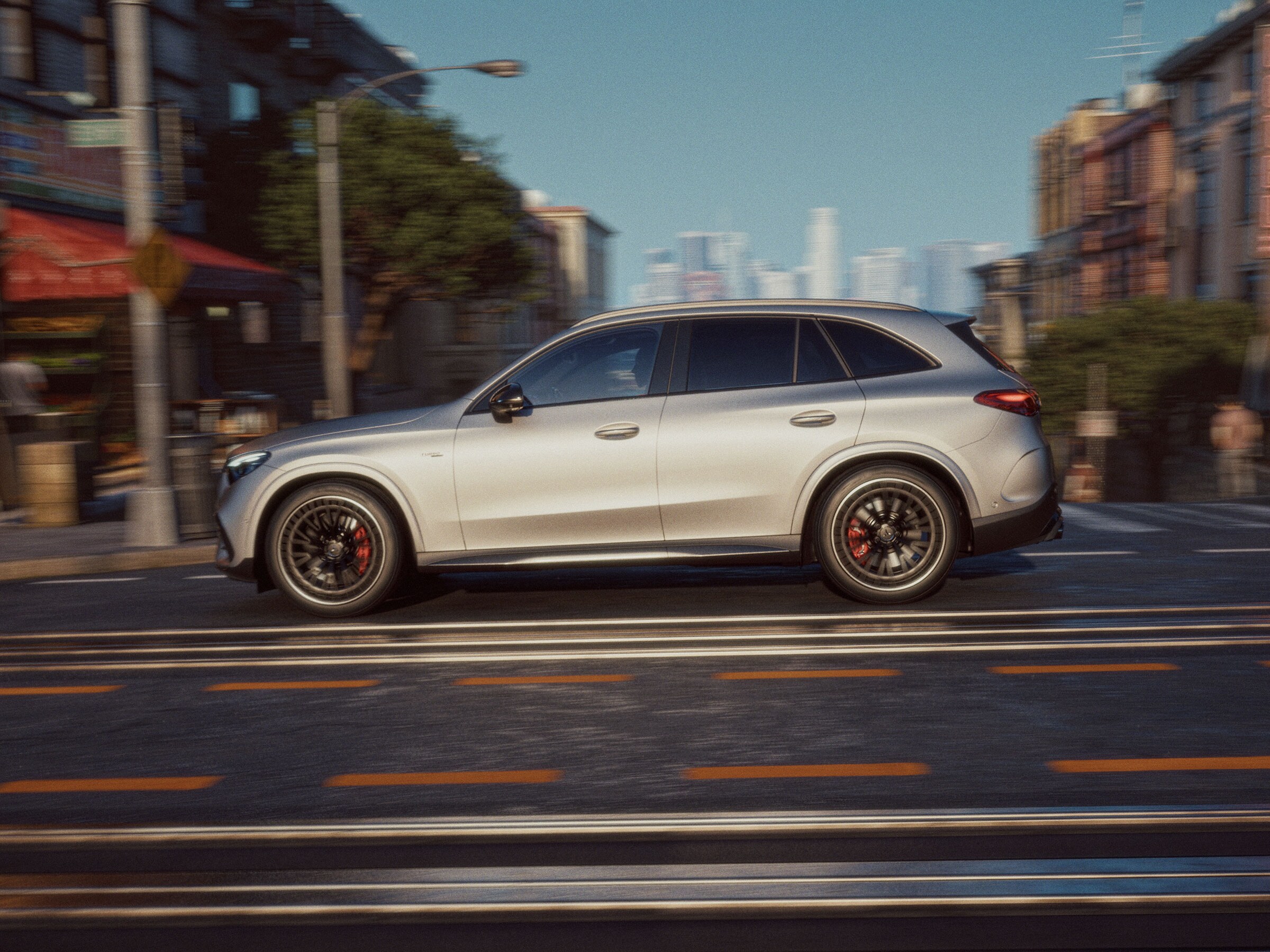 Vista lateral de un Mercedes-AMG GLC gris por la carretera