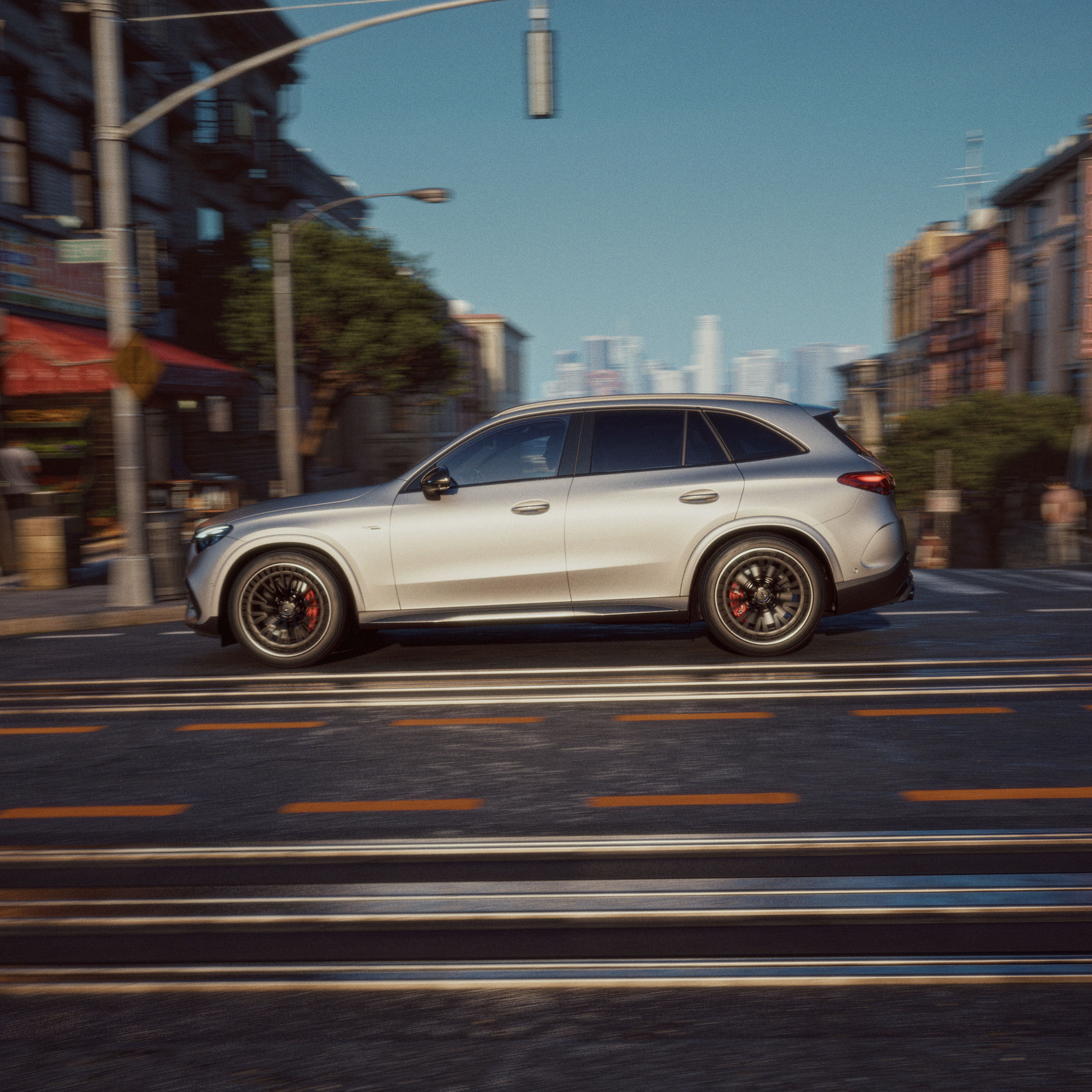 Visual lateral de un GLC de Mercedes-AMG gris circulando por una ciudad.