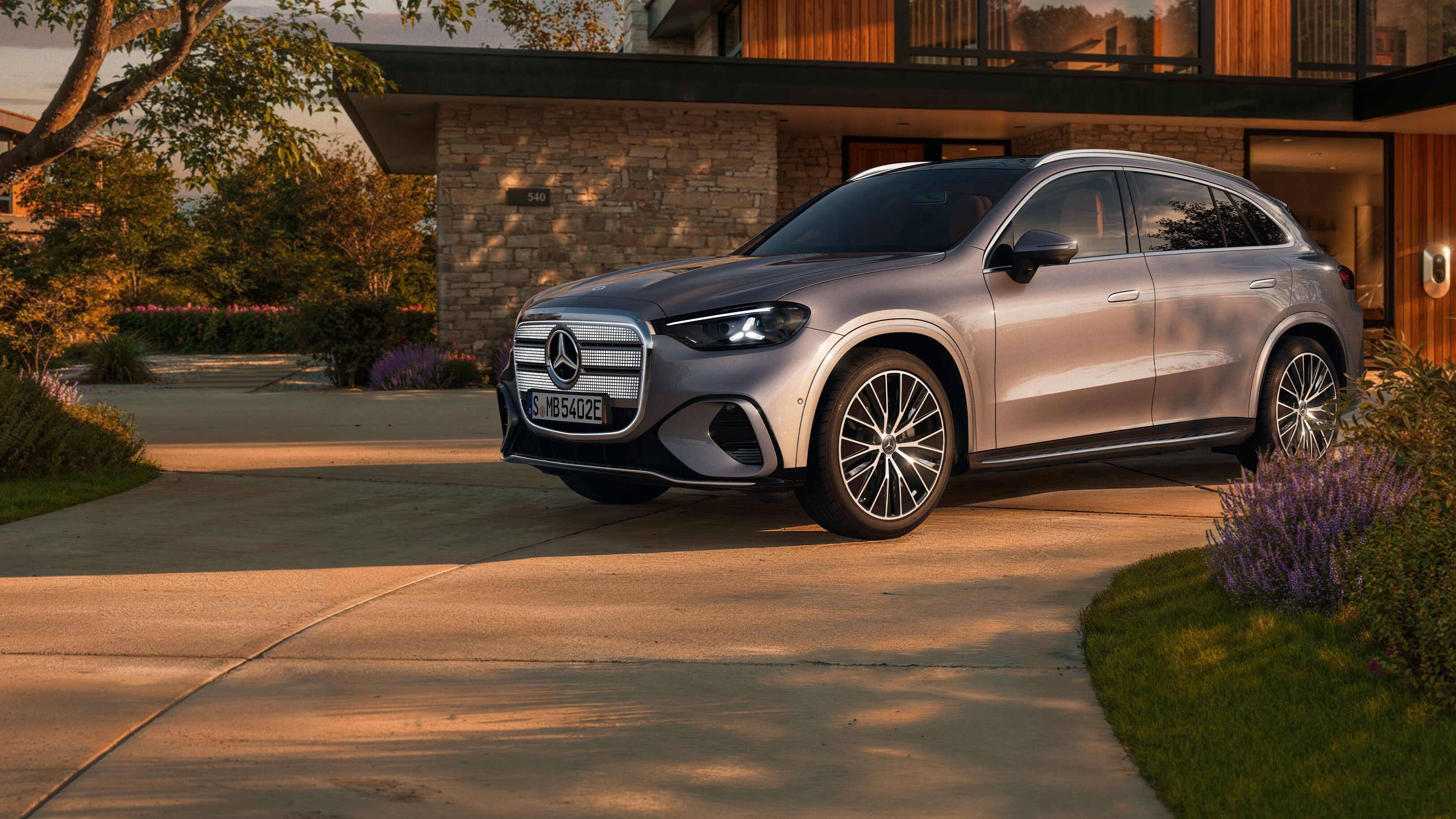 Visual aérea de un GLC plateado de Mercedes-Benz aparcado al frente de una casa