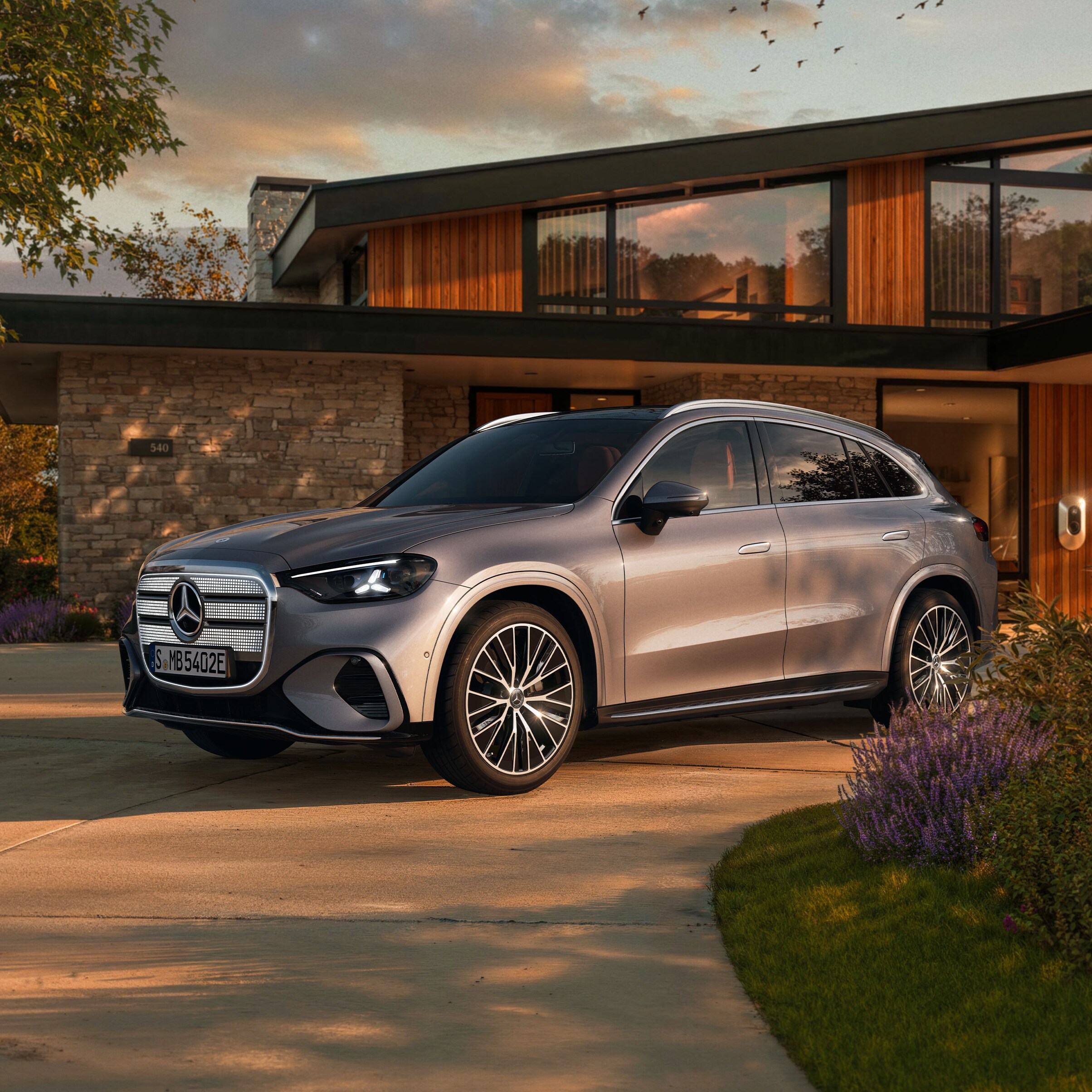 Visual de un GLC plateado de Mercedes-Benz aparcado al frente de una casa