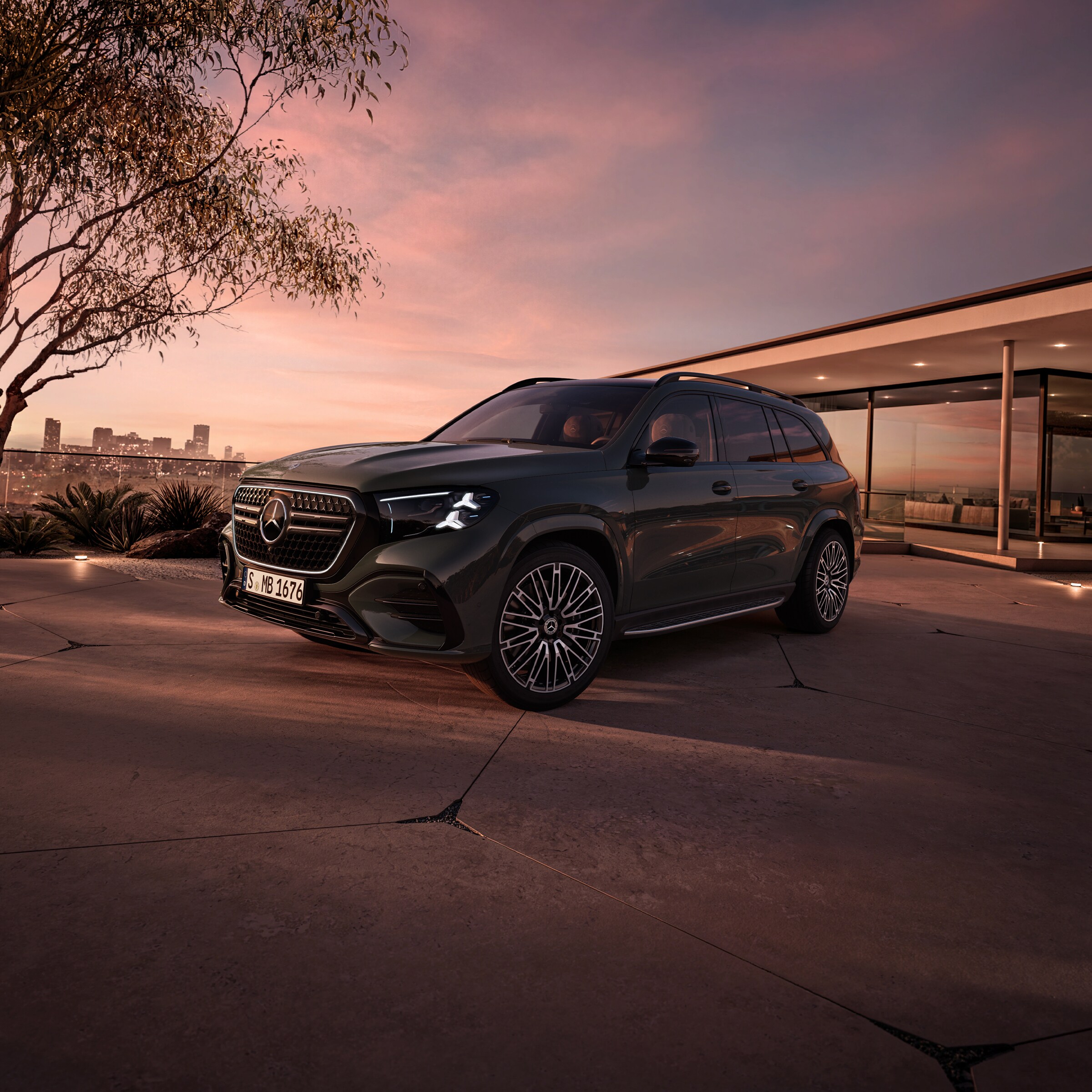 Visual lateral frontal del nuevo GLS en negro de Mercedes-Benz aparcado frente de una casa