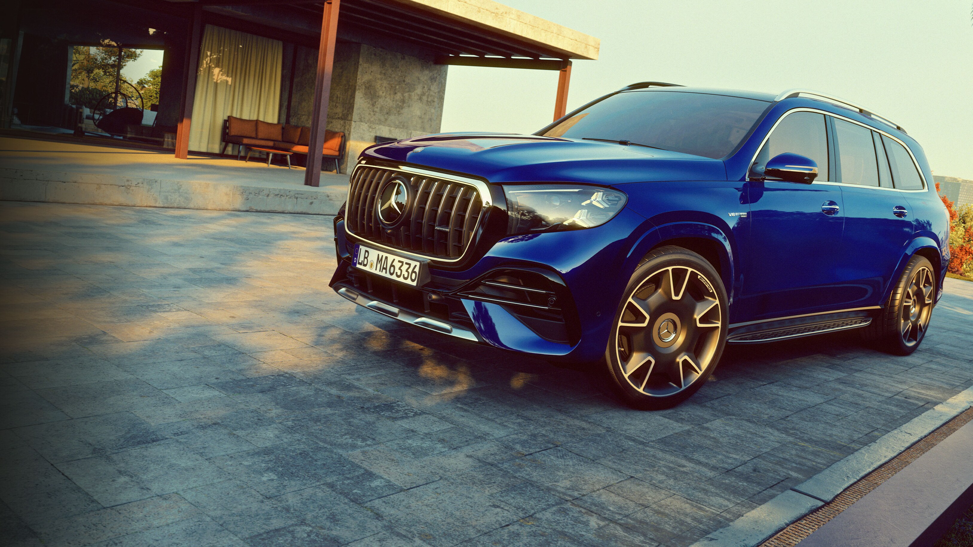 visual del lateral del nuevo Mercedes-AMG GLS azul aparcado fuera de una casa
