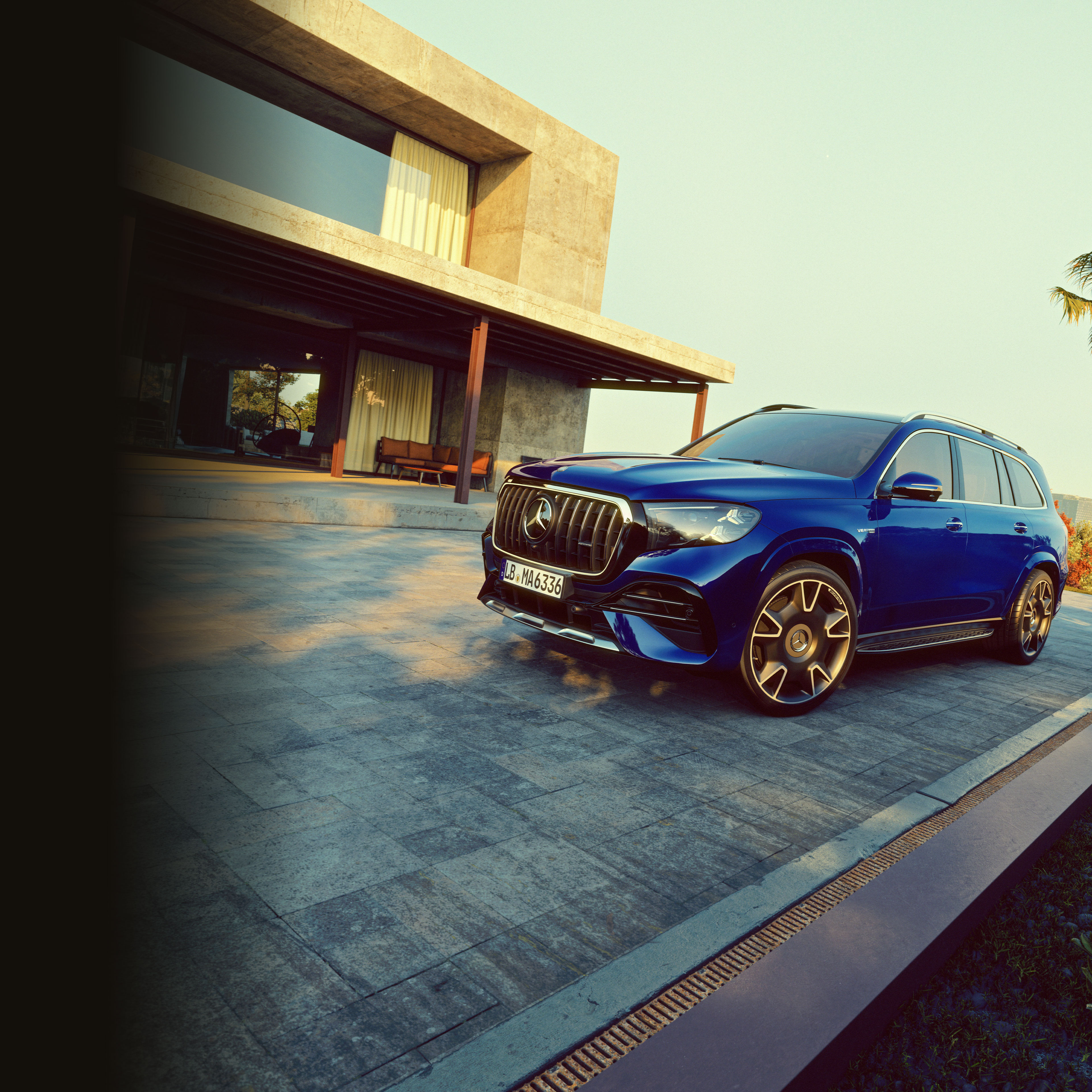visual del lateral del nuevo Mercedes-AMG GLS azul aparcado fuera de una casa