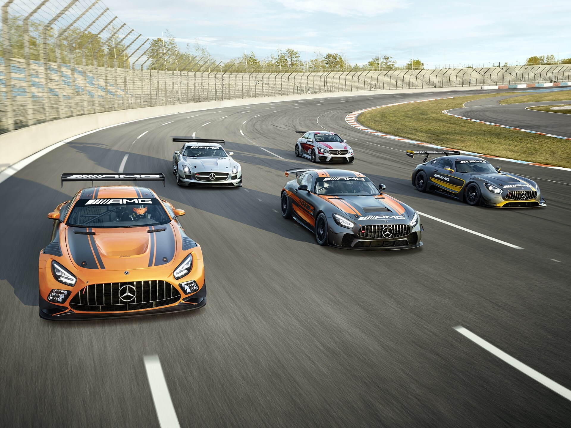 Varios vehículos Mercedes-AMG en un circuito de carreras.