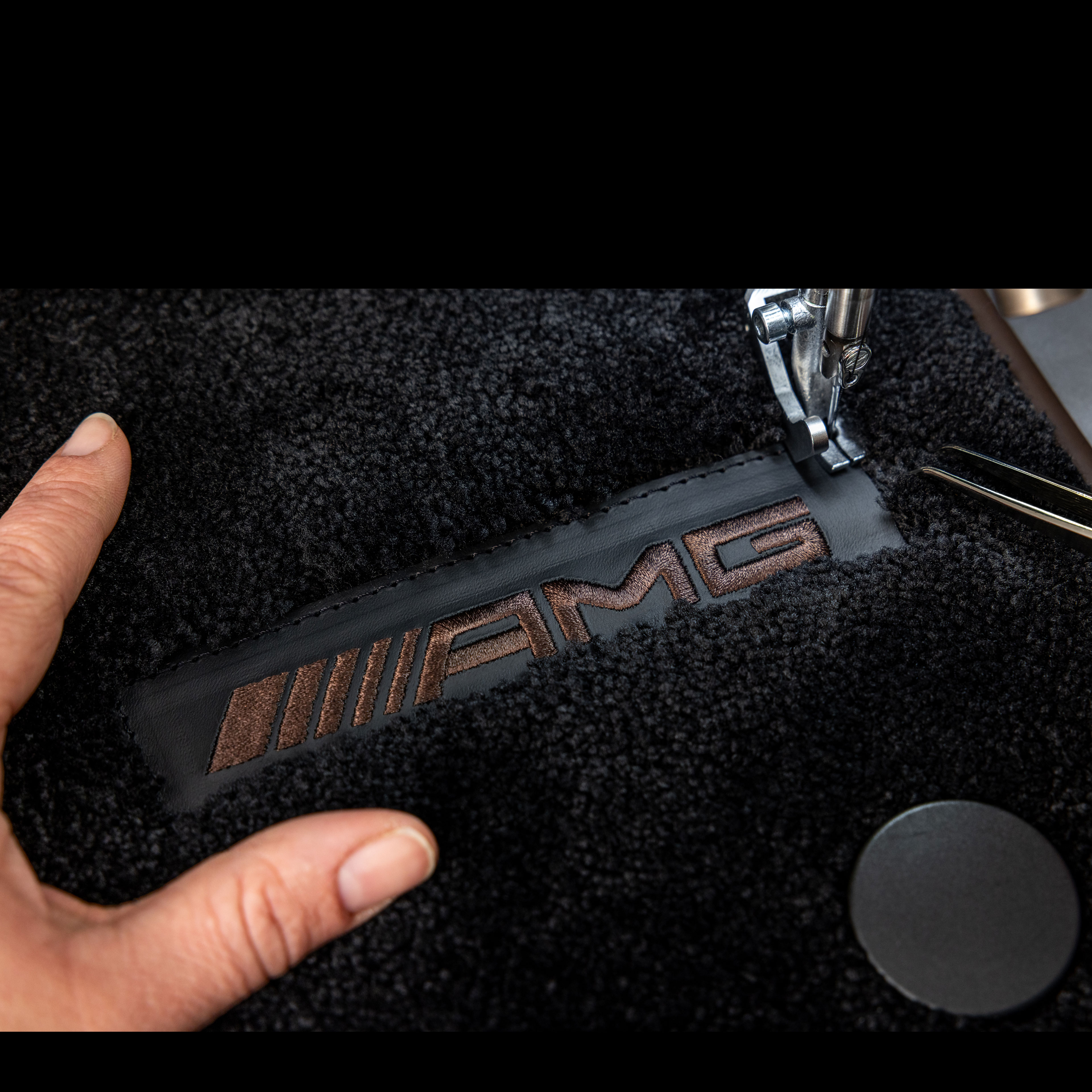 MANUFAKTUR | Mercedes-AMG Inscripción MANUFAKTUR sobre una superficie oscura en un Mercedes-AMG.