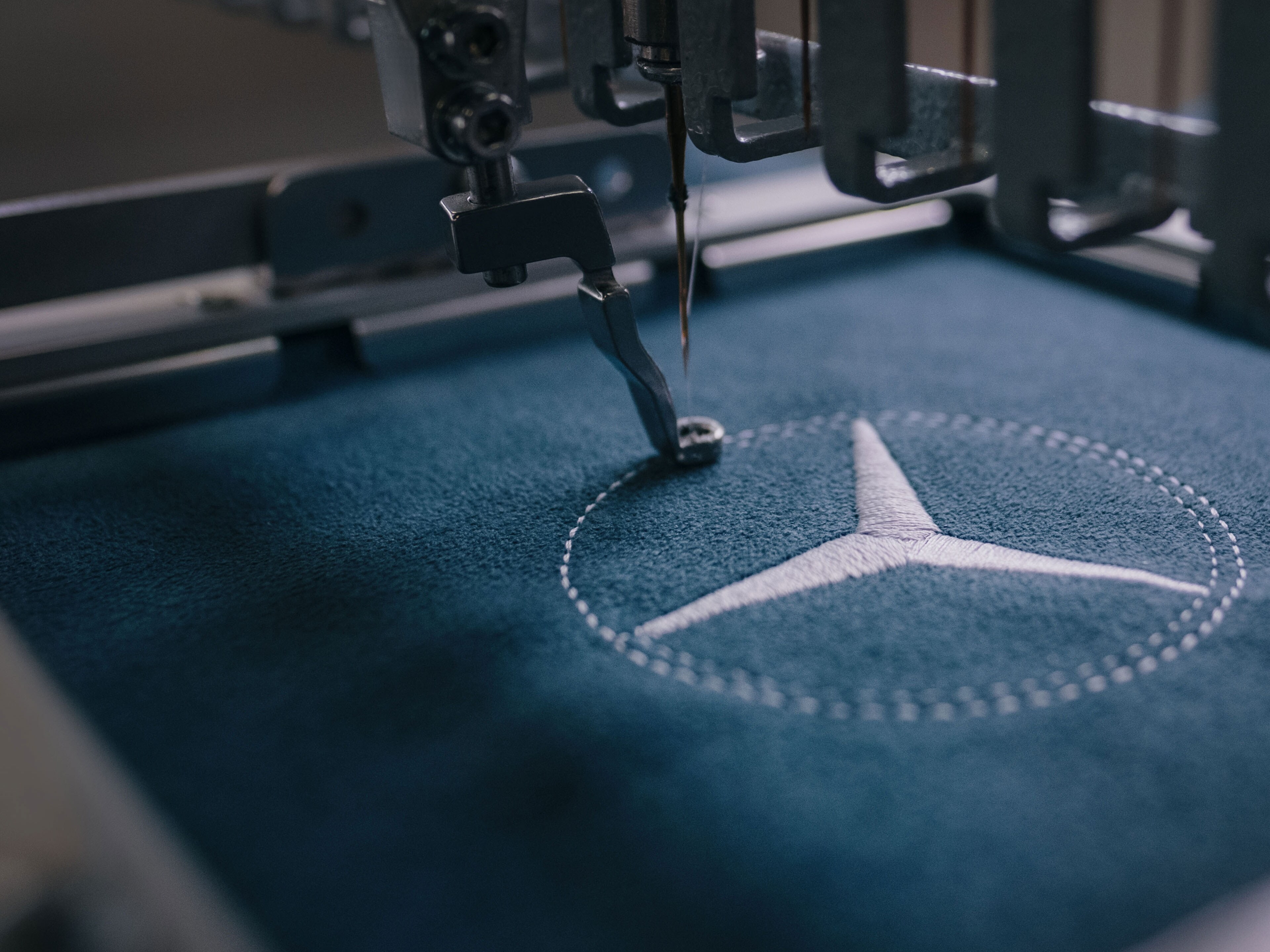 imagen de una maquina de coser tejiendo la estrella de Mercedes-Benz
