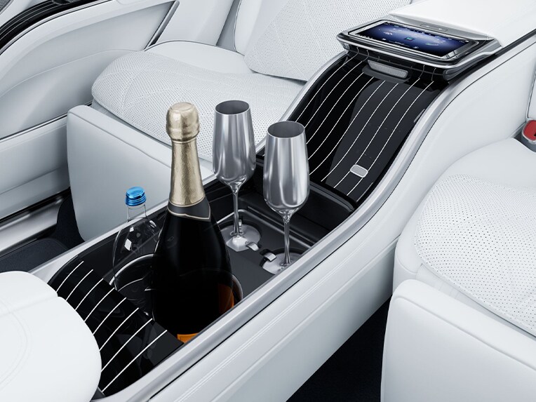 Compartimento refrigerado con copas de champán y portavasos en el lujoso Mercedes-Maybach EQS SUV.