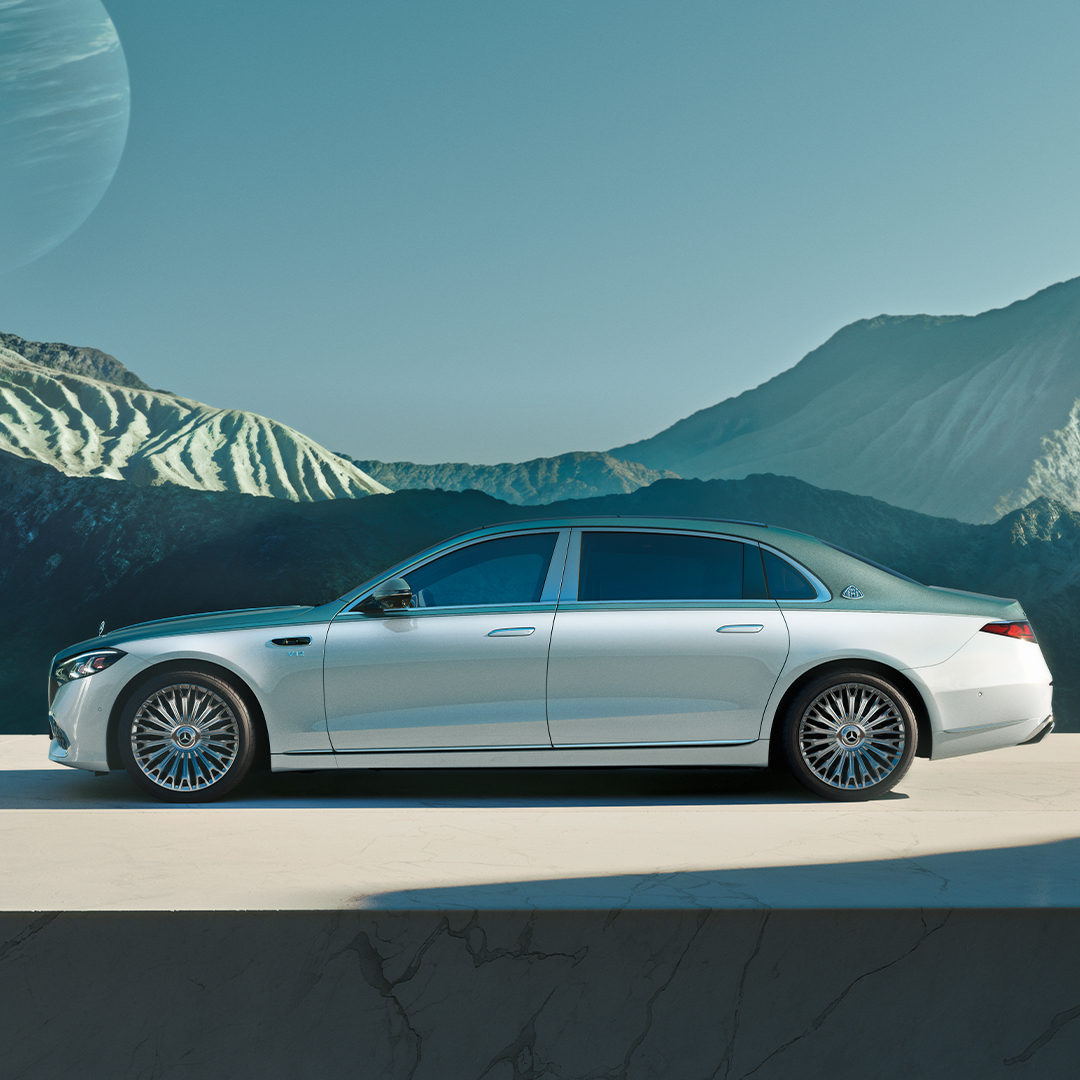 visual lateral del Mercedes-Maybach Clase S en color gris y verde frente a una montaña