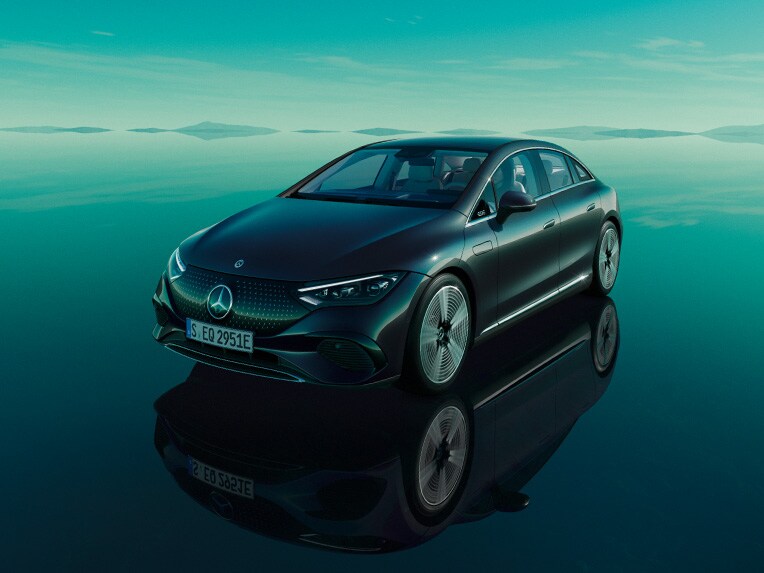 El EQE Berlina 100% eléctrico de Mercedes-Benz posa en su mundo EQ verde, sobre un suelo reflectante.
