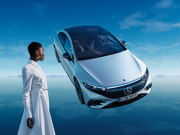 El EQS Berlina 100% eléctrico de Mercedes-Benz posa en su mundo EQ azul, sobre un suelo reflectante.