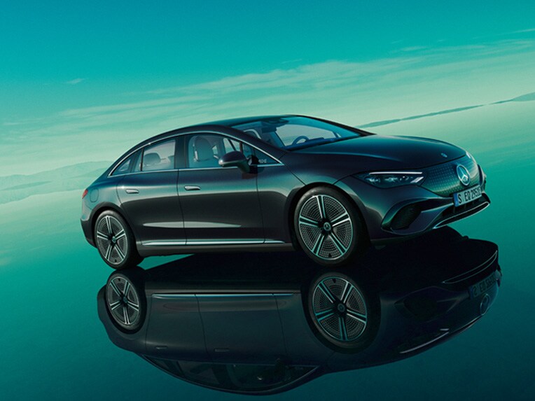 El EQE 100% eléctrico de Mercedes-Benz posa en su mundo EQ verde, sobre un suelo reflectante.