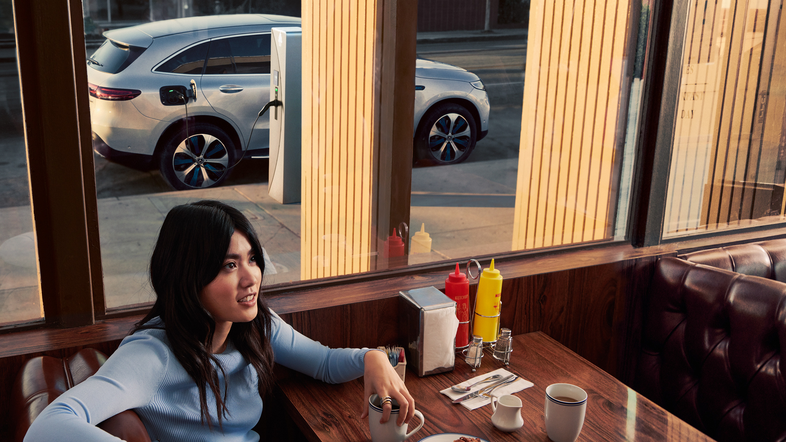 Carga en estaciones públicas con Mercedes-Benz Una persona esperando en el restaurante mientras carga su Mercedes-Benz