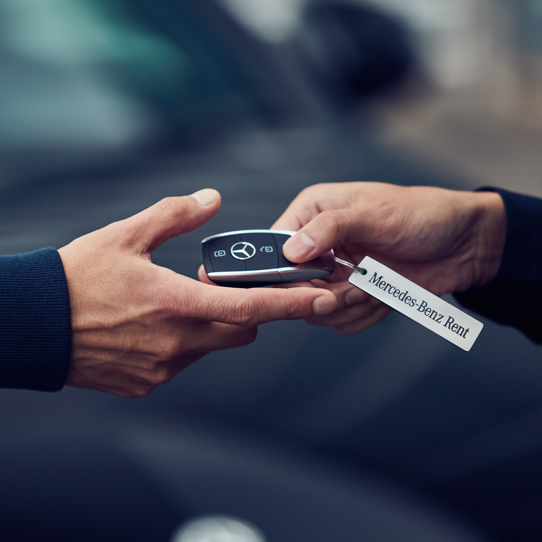 Alquiler | Servicios financieros | Mercedes-Benz Dos manos en el momento de entrega de una llave Mercedes-Benz.