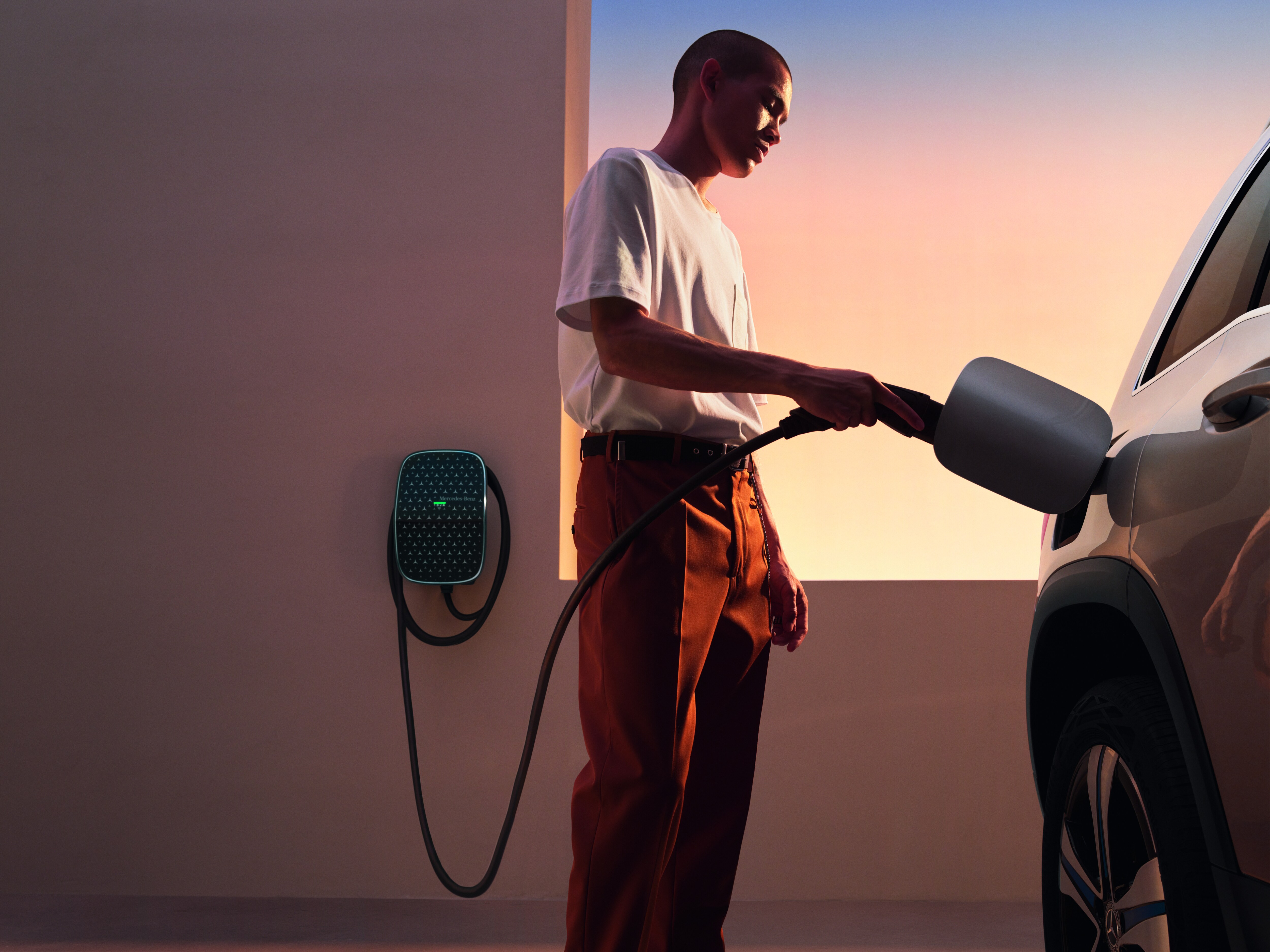 Una persona cargando un vehículo eléctrico Mercedes-Benz con una Mercedes-Benz Wallbox
