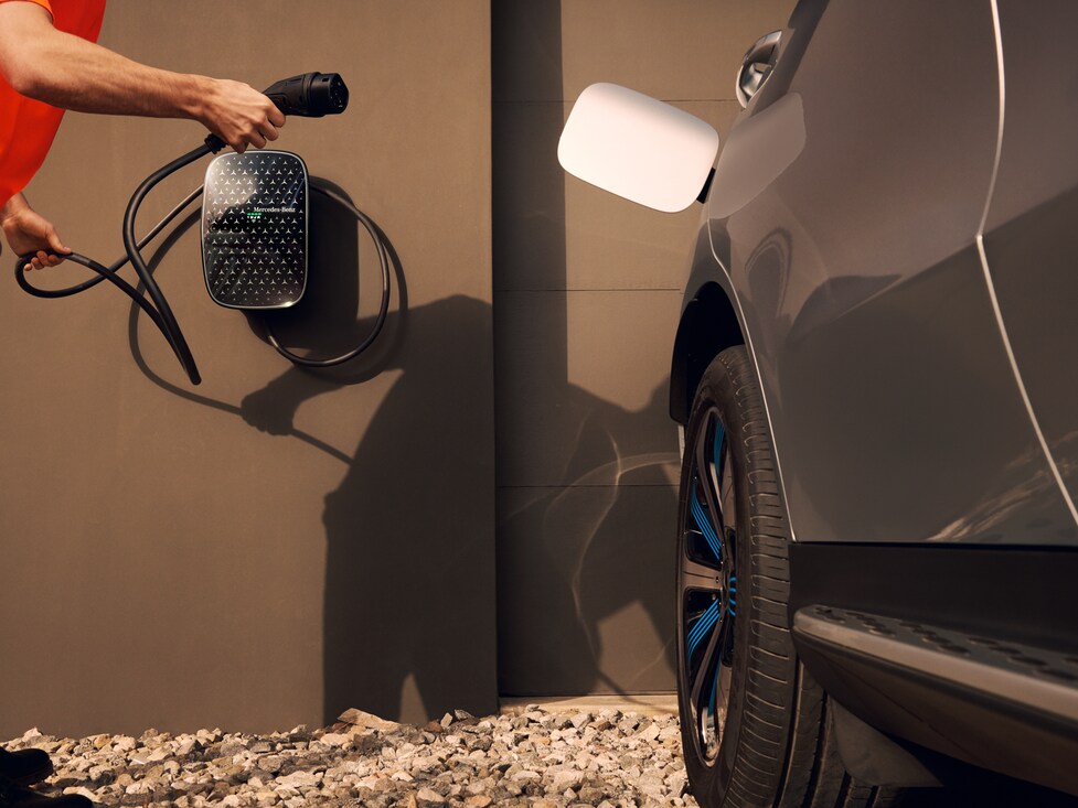 Una persona cargando un Mercedes-Benz EQS SUV con el Mercedes-Benz Wallbox LTE-M