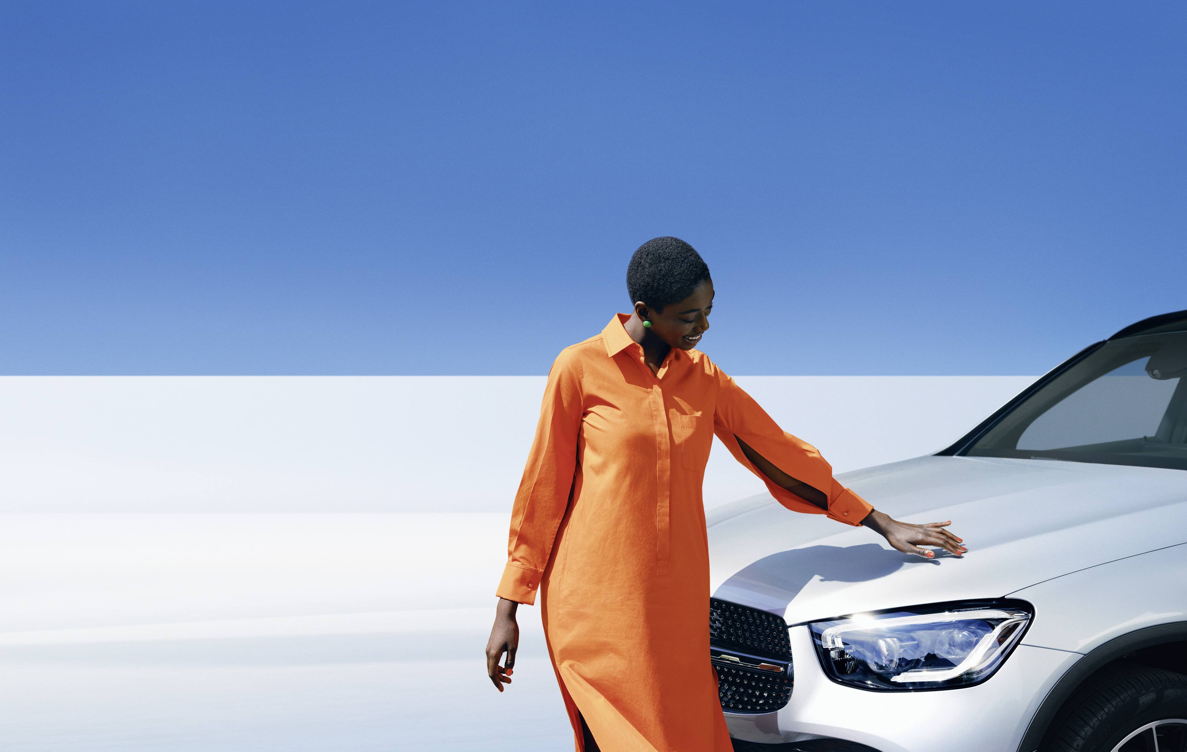Cuidado del automóvil original | Mercedes-Benz Una mujer examina su Mercedes-Benz.