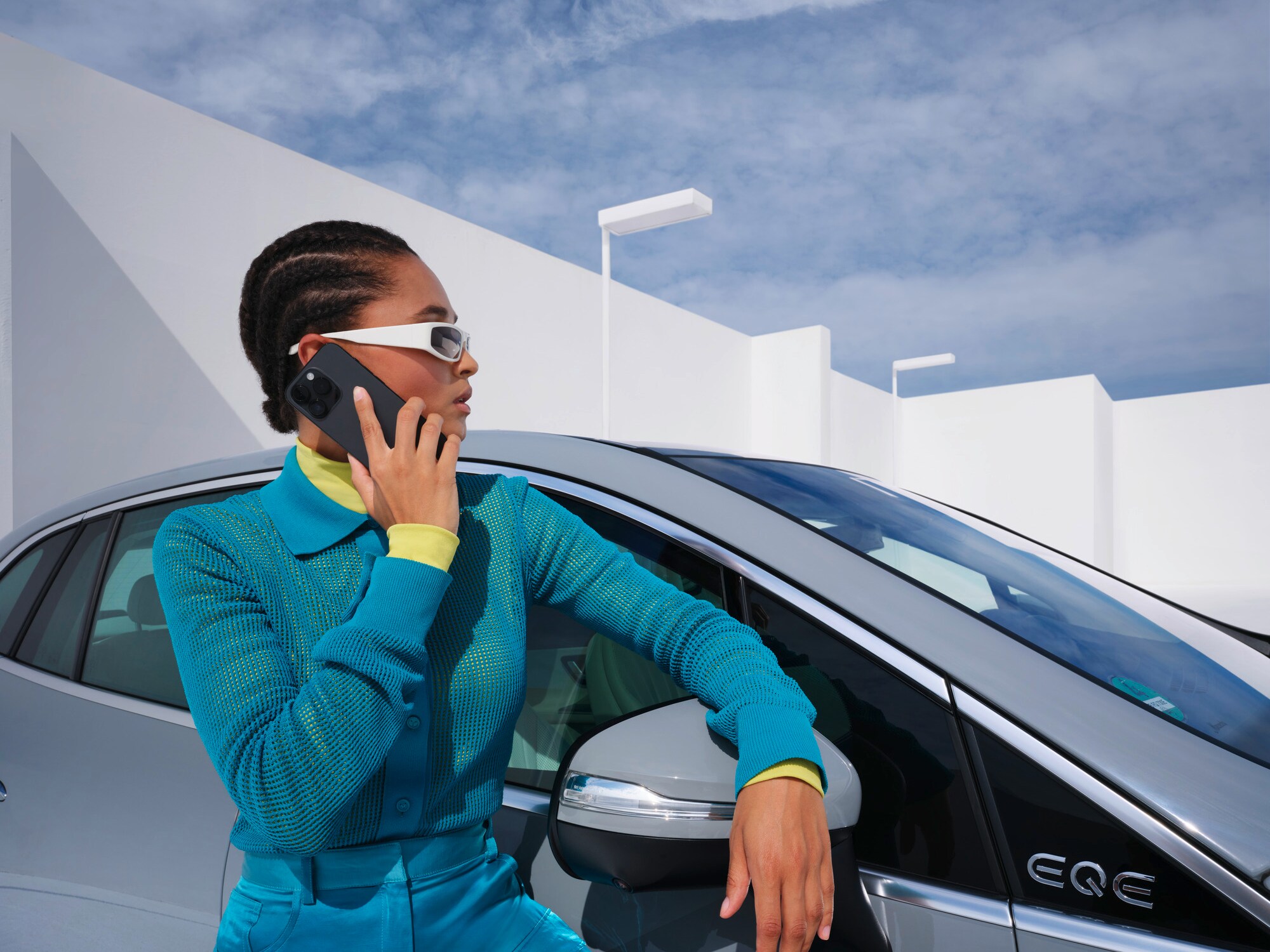 Imagen mostrando una persona apoyada en un vehículo Mercedes-Benz con el teléfono en la mano.