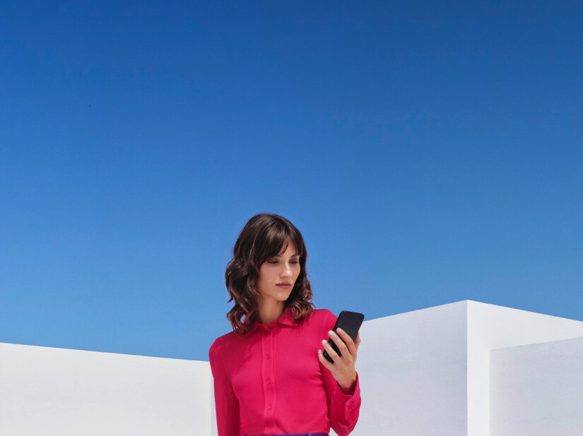 Mujer hablando por teléfono delante de su Mercedes-Benz