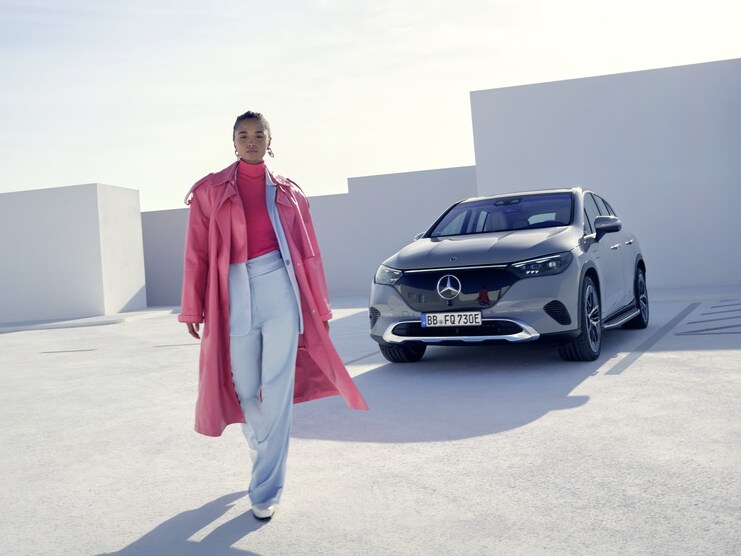 Una mujer alejándose caminando de su Mercedes-Benz.