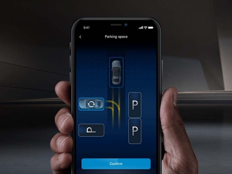 Un Mercedes-Benz aparca con ayuda del smartphone gracias al asistente para aparcar a distancia de Mercedes.