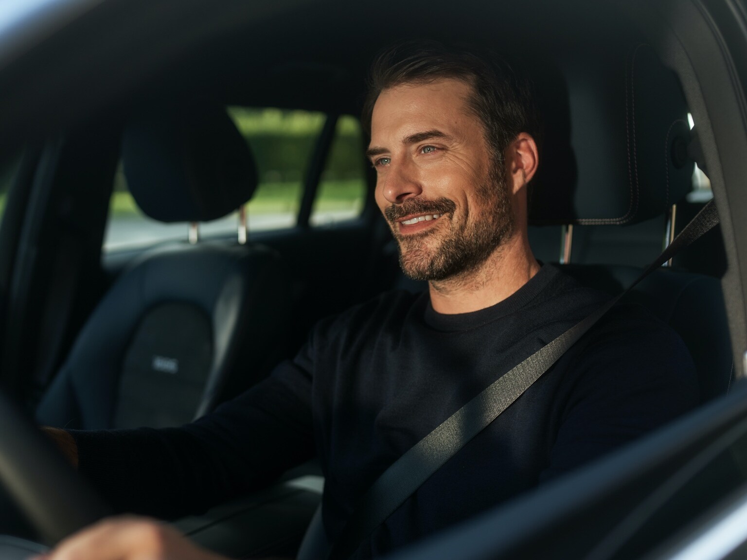 Un hombre escucha la radio por Internet sin interrupciones en su Mercedes-Benz gracias al paquete Entretenimiento.