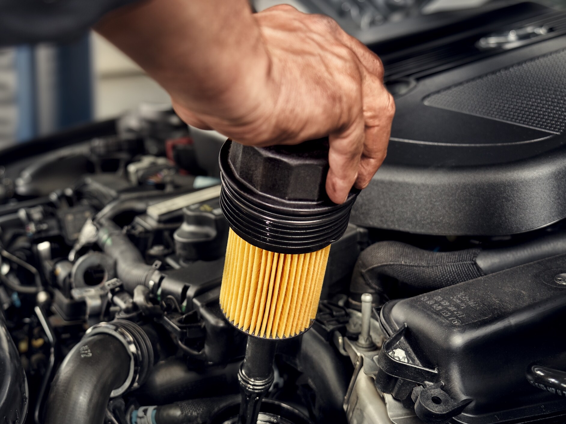 Un técnico instalando el filtro de aceite a un vehículo Mercedes-Benz.